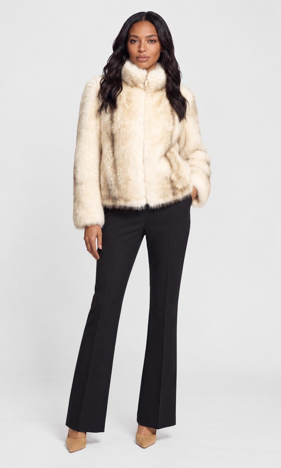Model wearing a cream faux fur jacket with a high collar, paired with black flared pants and beige heels.