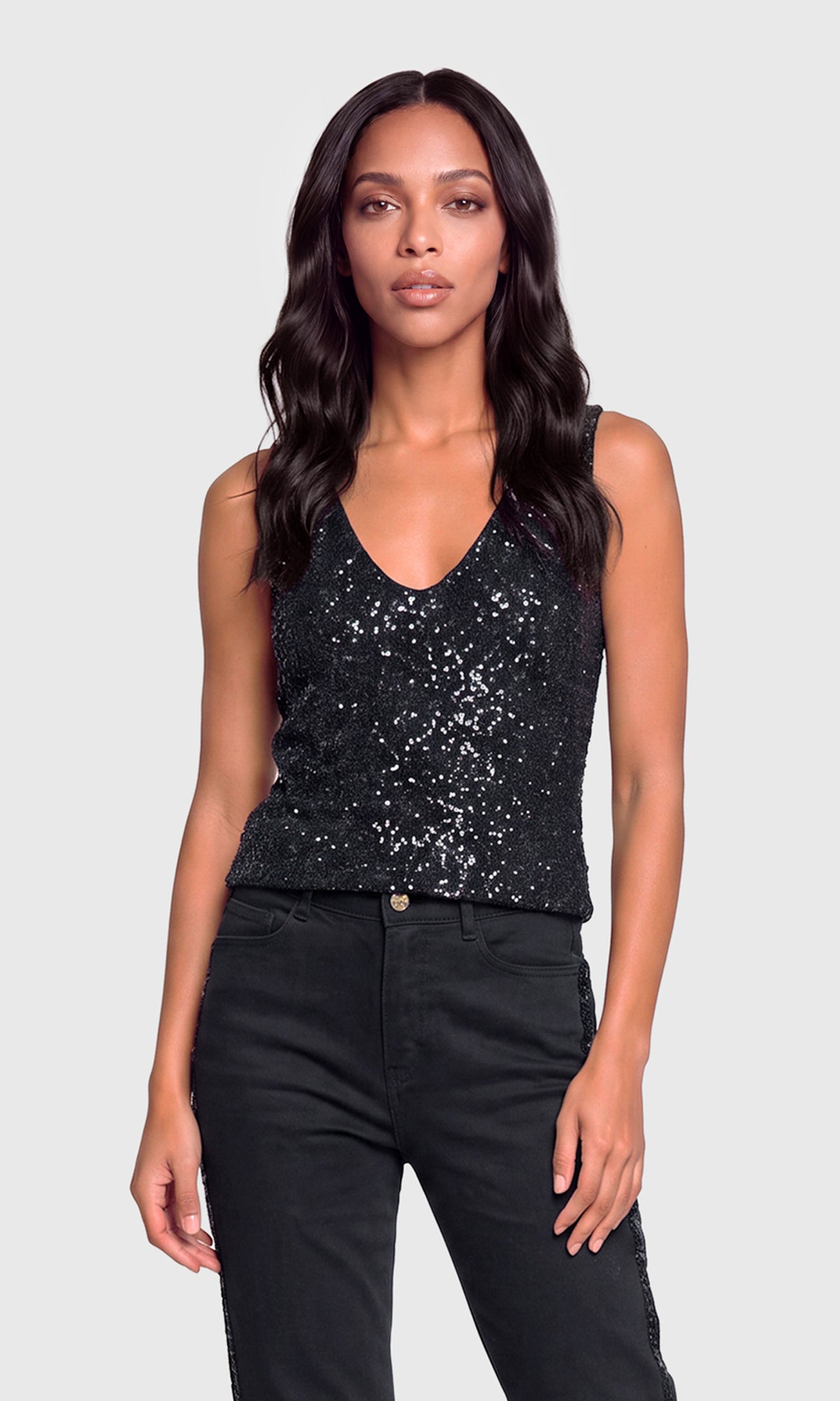 Model wearing a black sequined sleeveless tank top paired with black jeans.