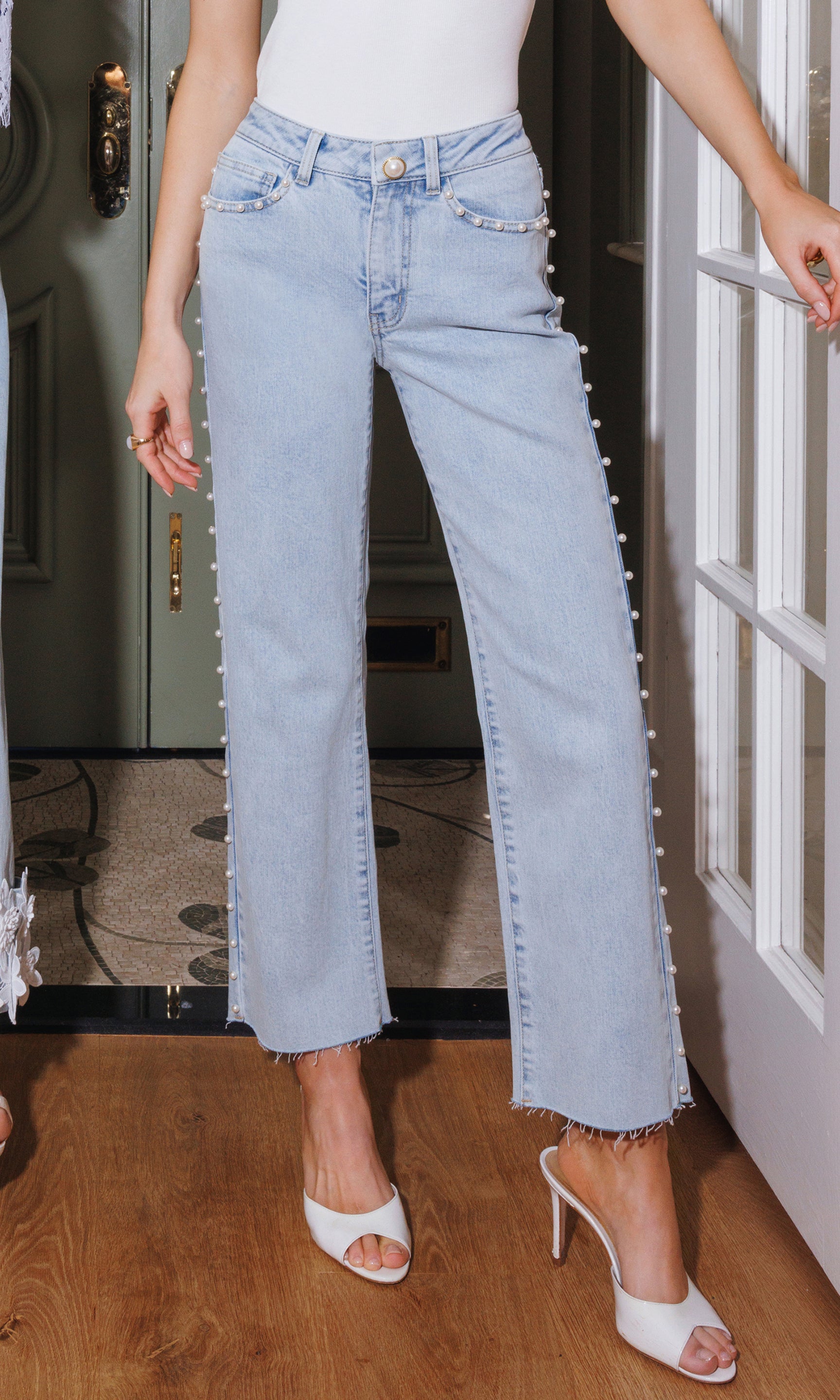 In an editorial front view, the model wears the Han Pearl Jeans in light blue, showing the straight-leg fit with a cropped frame from waist to heel.