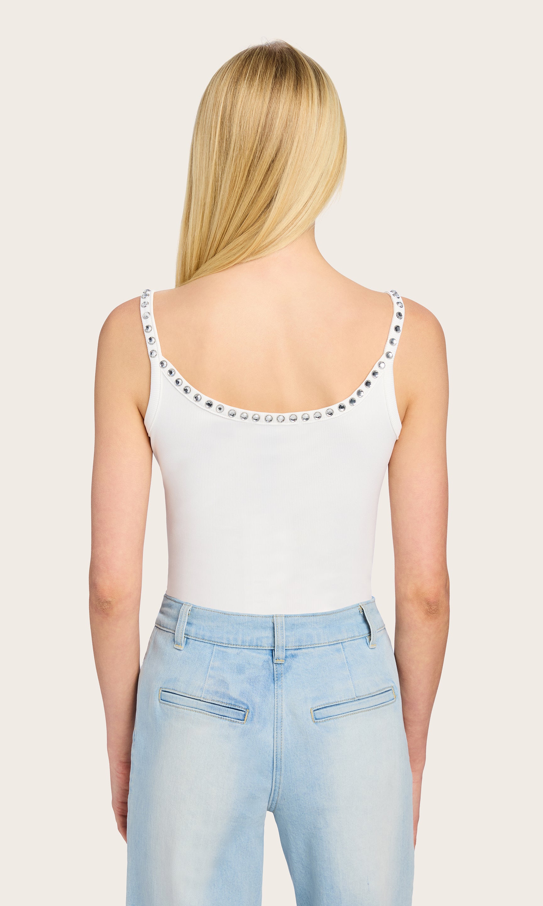 Rear view of the white Iris Crystal Tank Top styled with light denim, highlighting the slim straps and minimalist back cut.