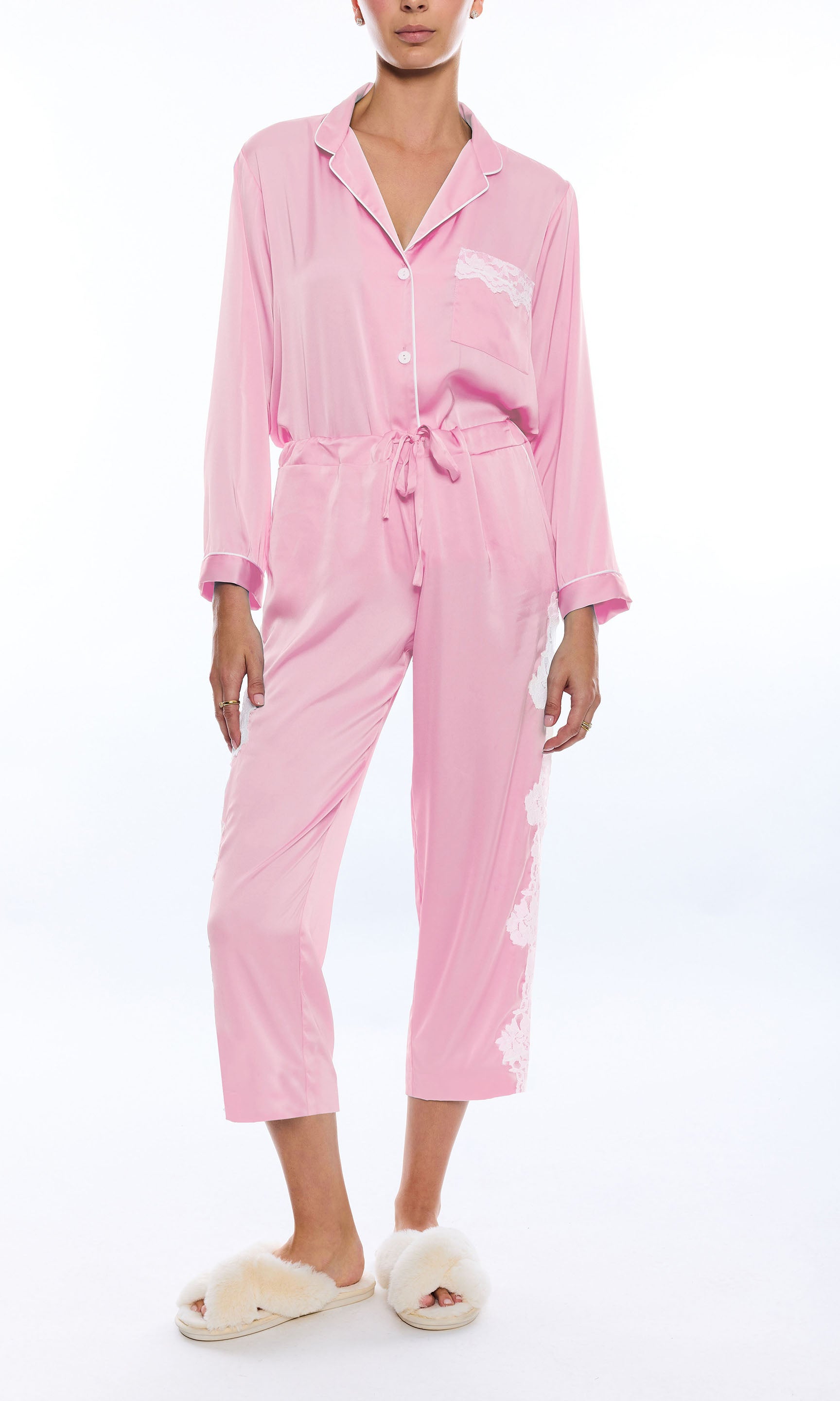 Person wearing a pink pajama set with a white background