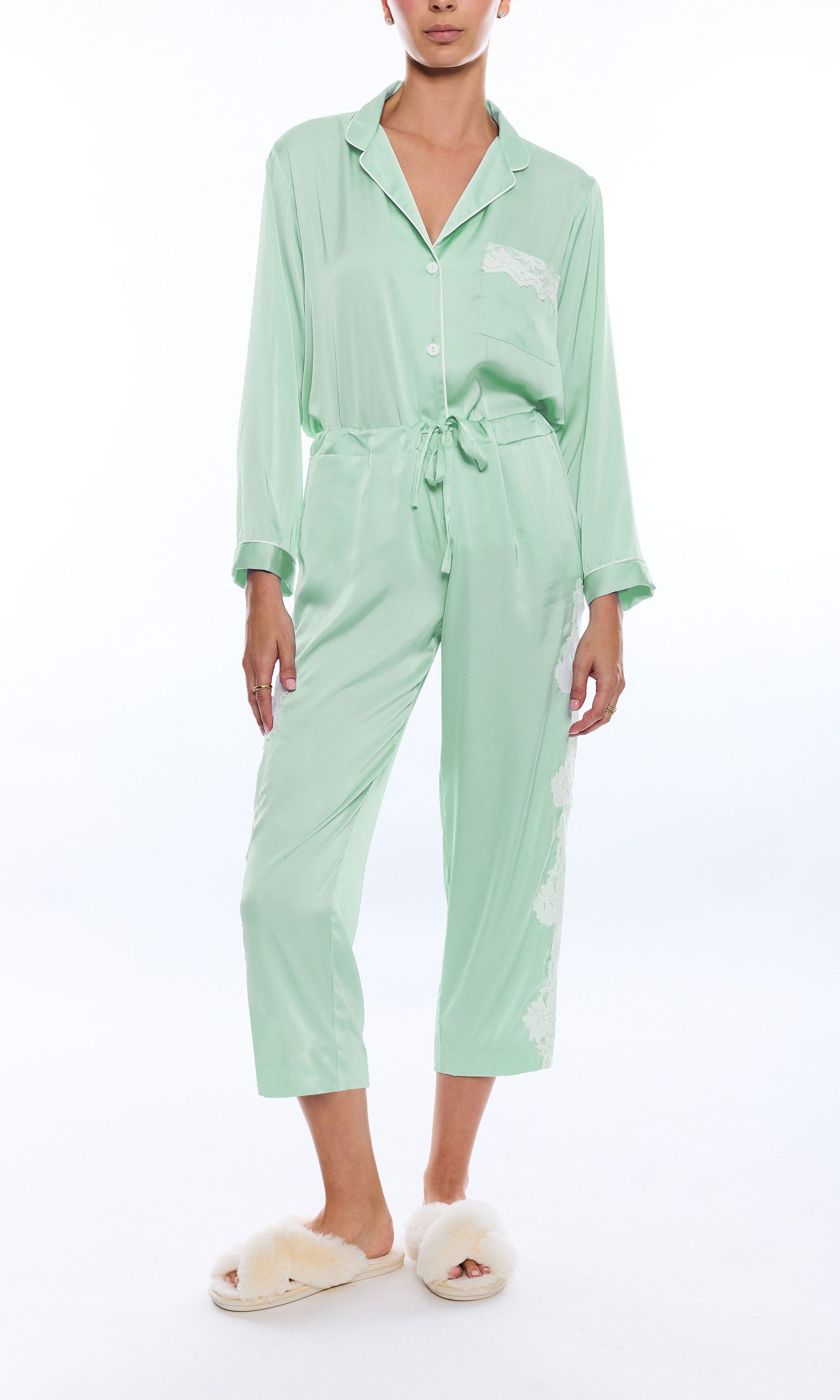 Person wearing a light green pajama set on a white background