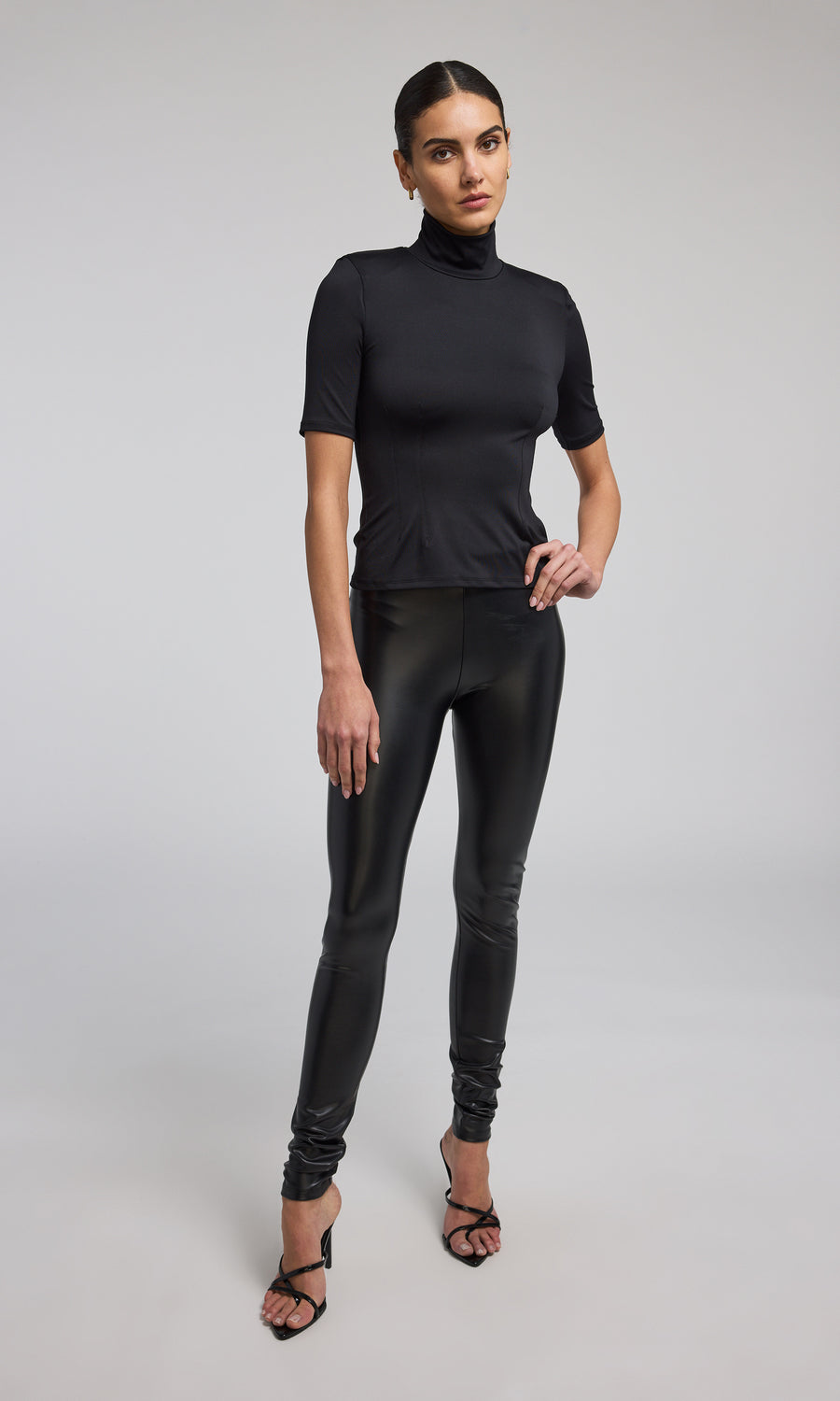 Stretchy black vegan leather leggings designed for a sleek fit, perfect for versatile fashion choices.