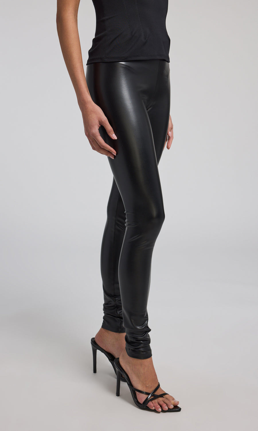 Stretchy black vegan leather leggings designed for a sleek fit, perfect for versatile fashion choices.