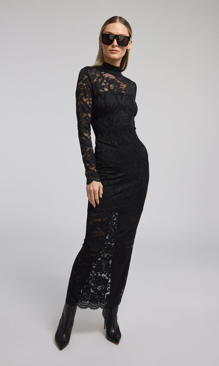 Elegant black lace dress with long sleeves, a high neck, and a striking high slit, perfect for formal occasions.