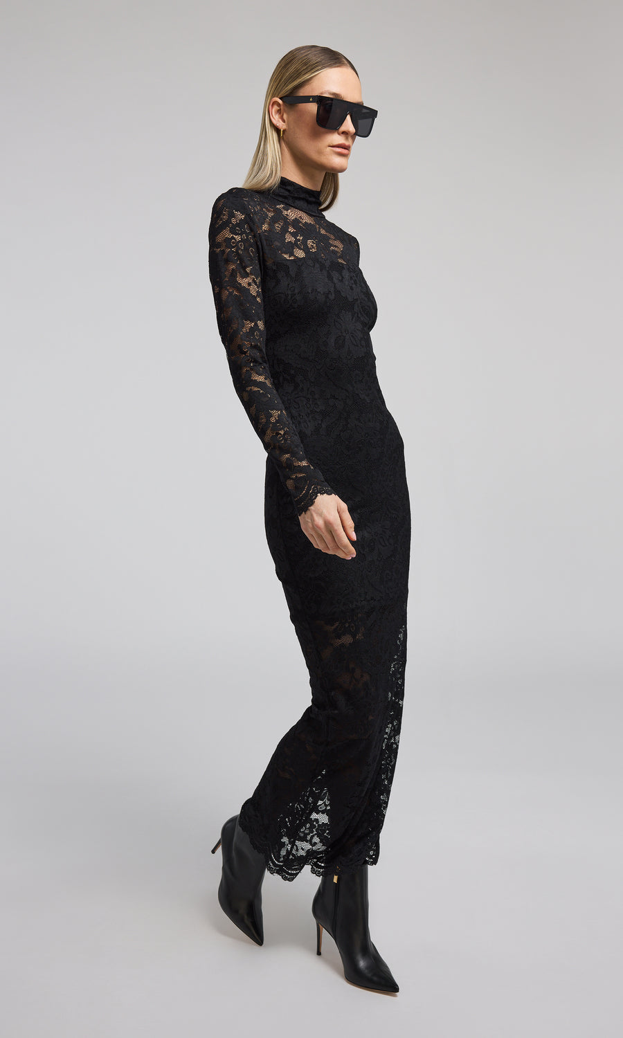 Elegant black lace dress with long sleeves, a high neck, and a striking high slit, perfect for formal occasions.