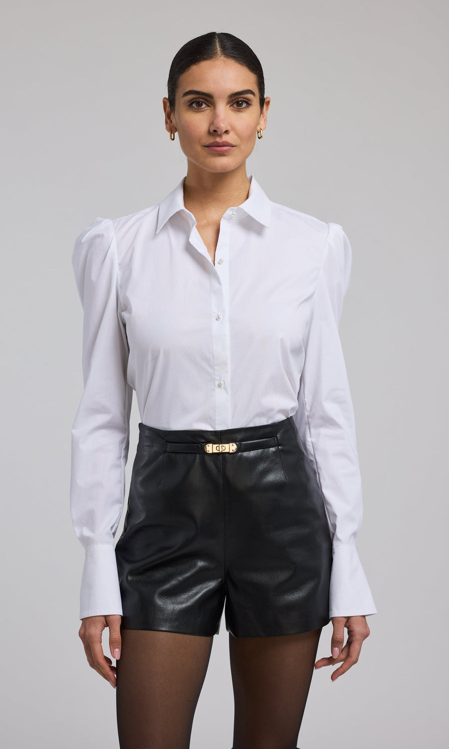  A model presents a fashionable white shirt, drawing attention to its clean lines and timeless style.