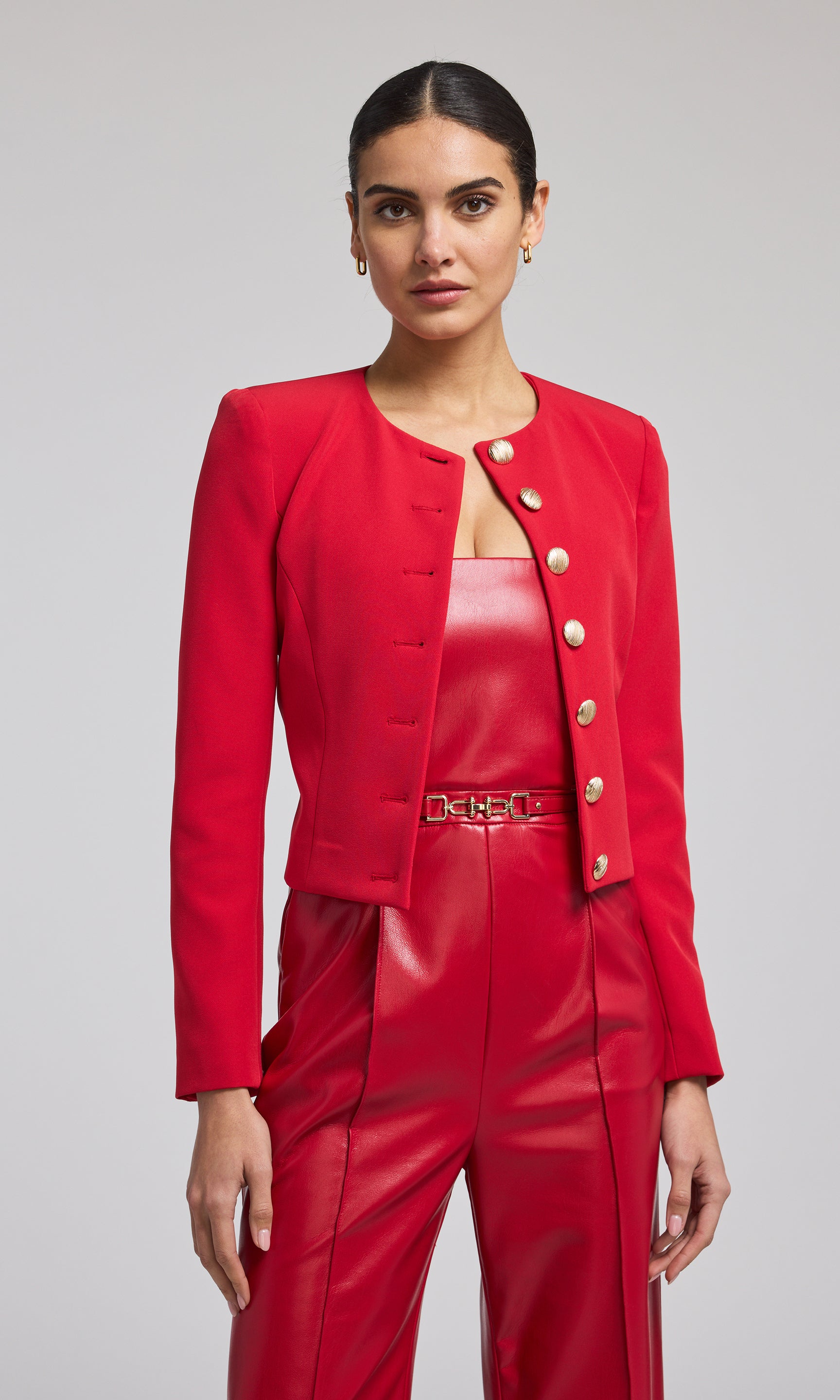 A vibrant red crepe blazer adorned with buttons, exemplifying contemporary fashion and elegance.