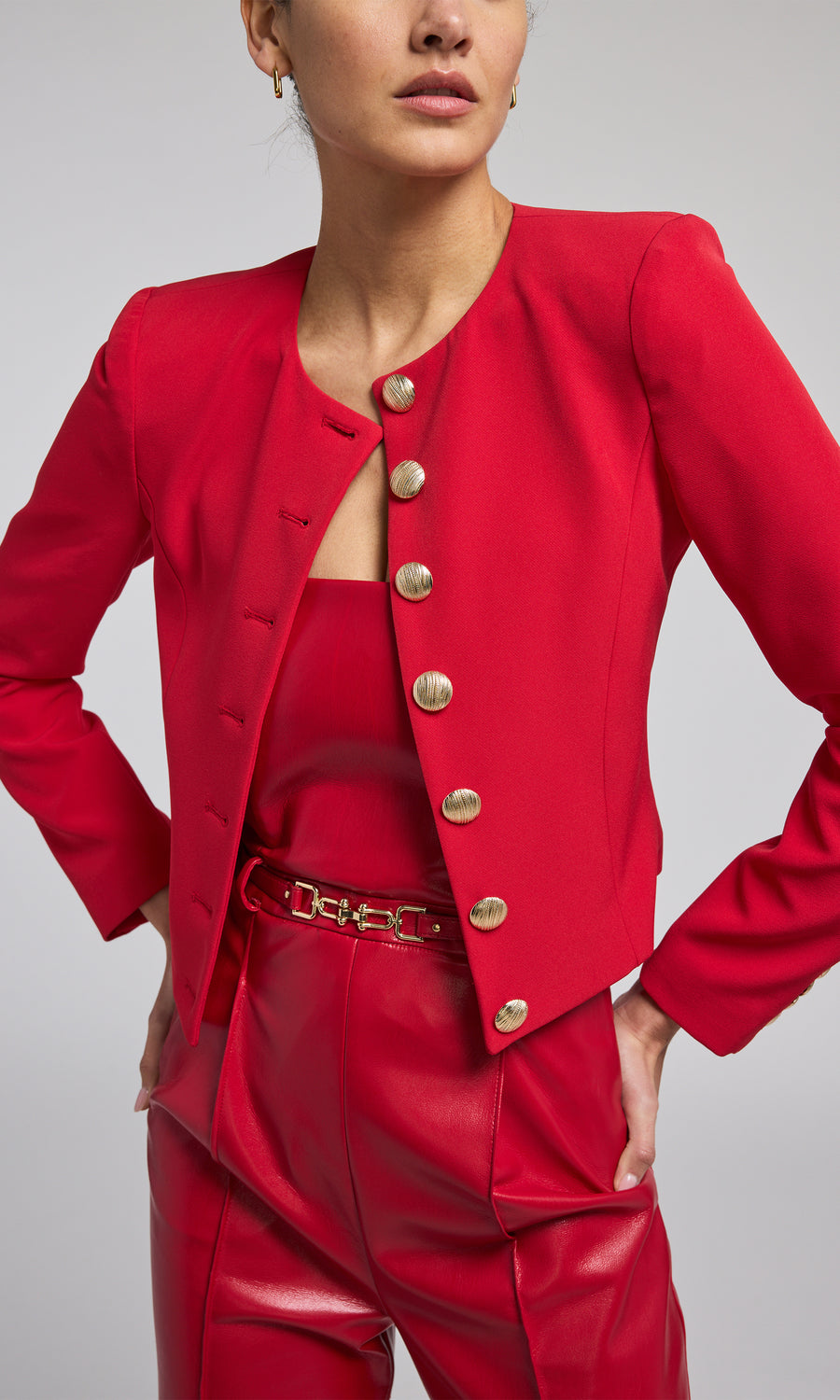 A vibrant red crepe blazer adorned with buttons, exemplifying contemporary fashion and elegance.