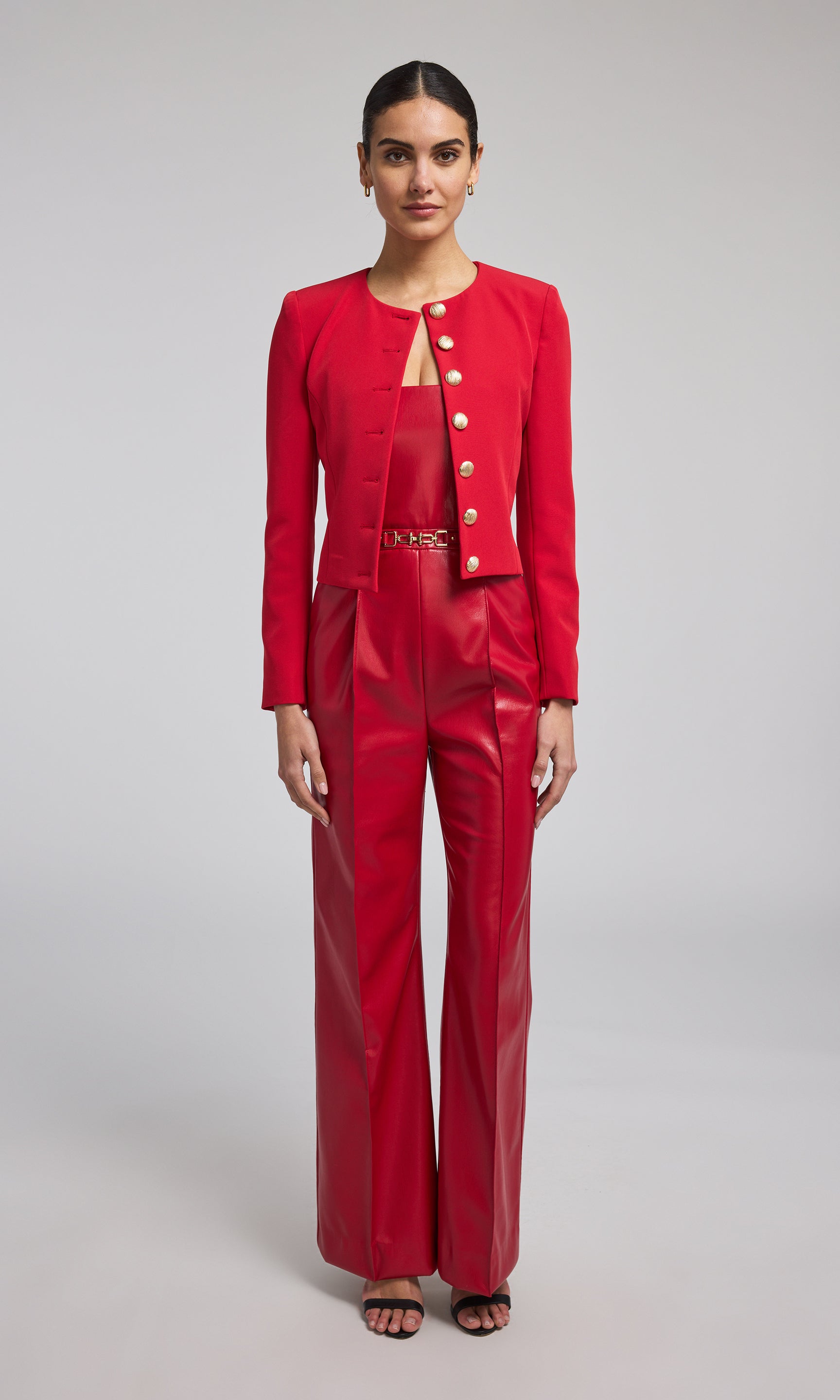 A vibrant red crepe blazer adorned with buttons, exemplifying contemporary fashion and elegance.