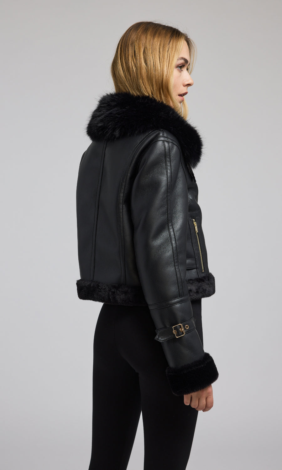 A fashionable shearing jacket with a plush faux fur collar is worn by the model, exemplifying a modern and stylish outfit.