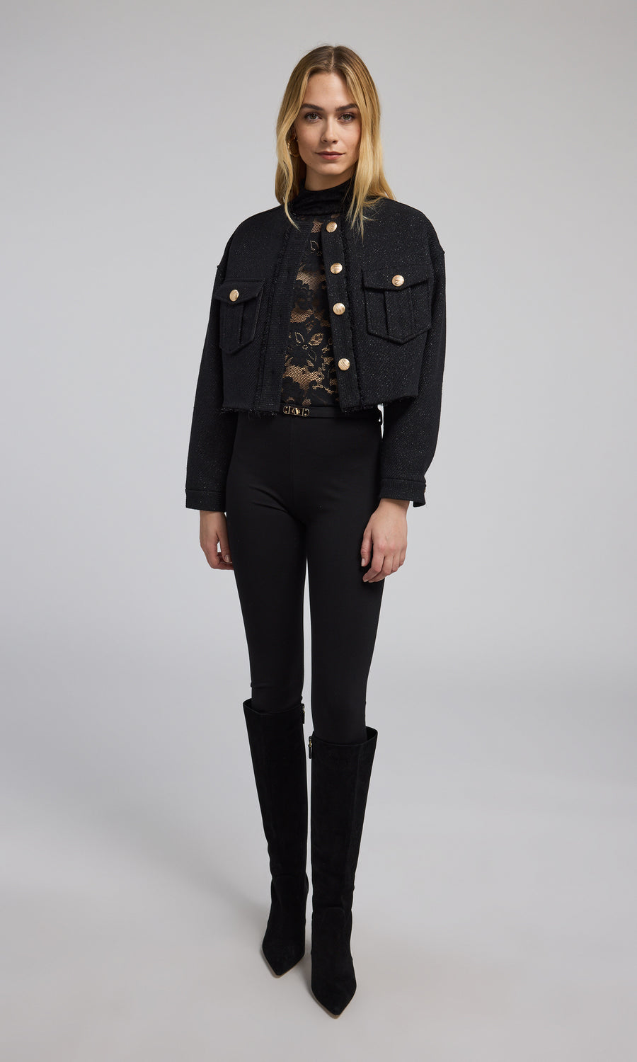 A stylish black cropped bomber jacket with gold buttons, emphasizing a modern and elegant look in outerwear fashion.