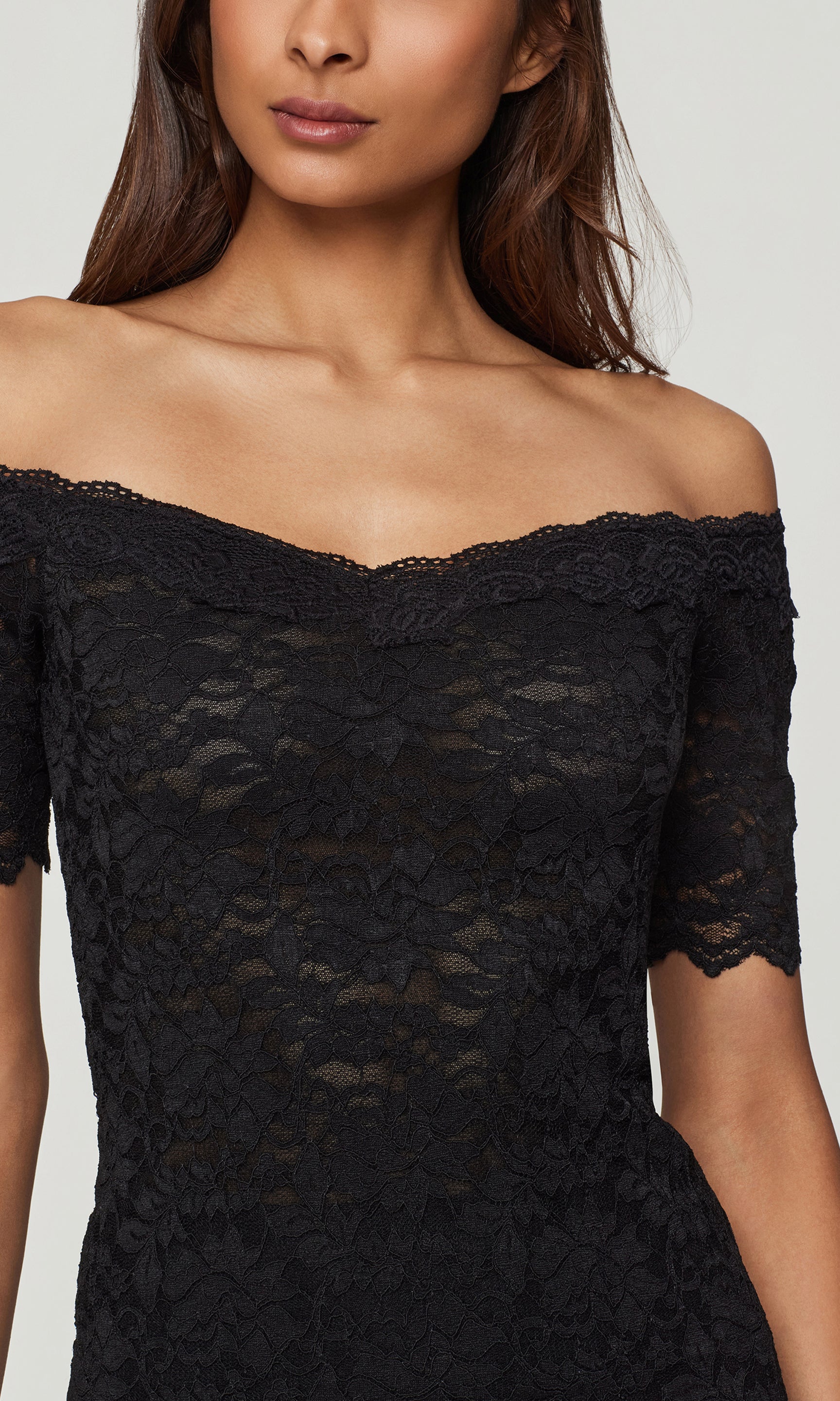 Close-up of black lace off-shoulder top against a plain background