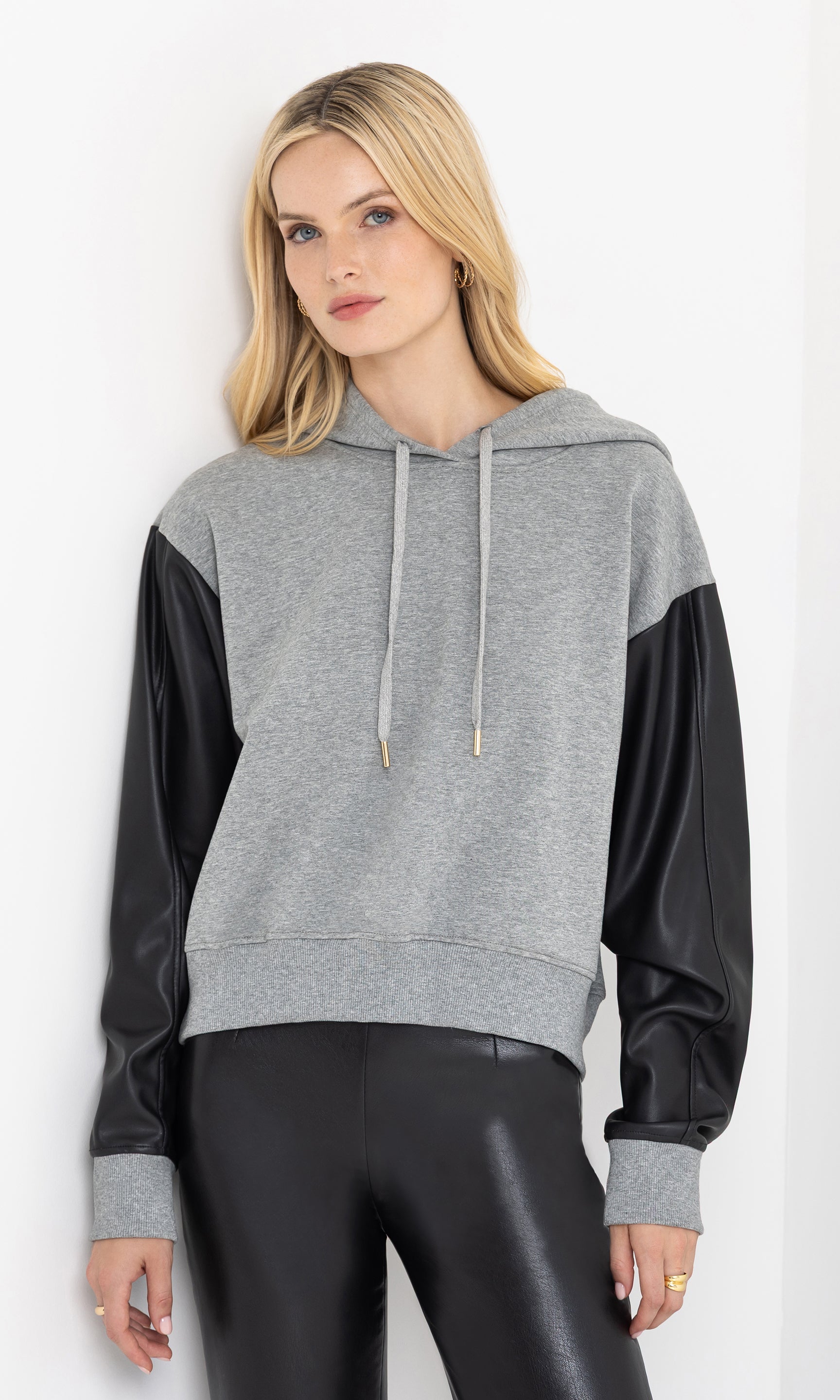 Front view of the model wearing the lisbet vegan leather combo hoodie.