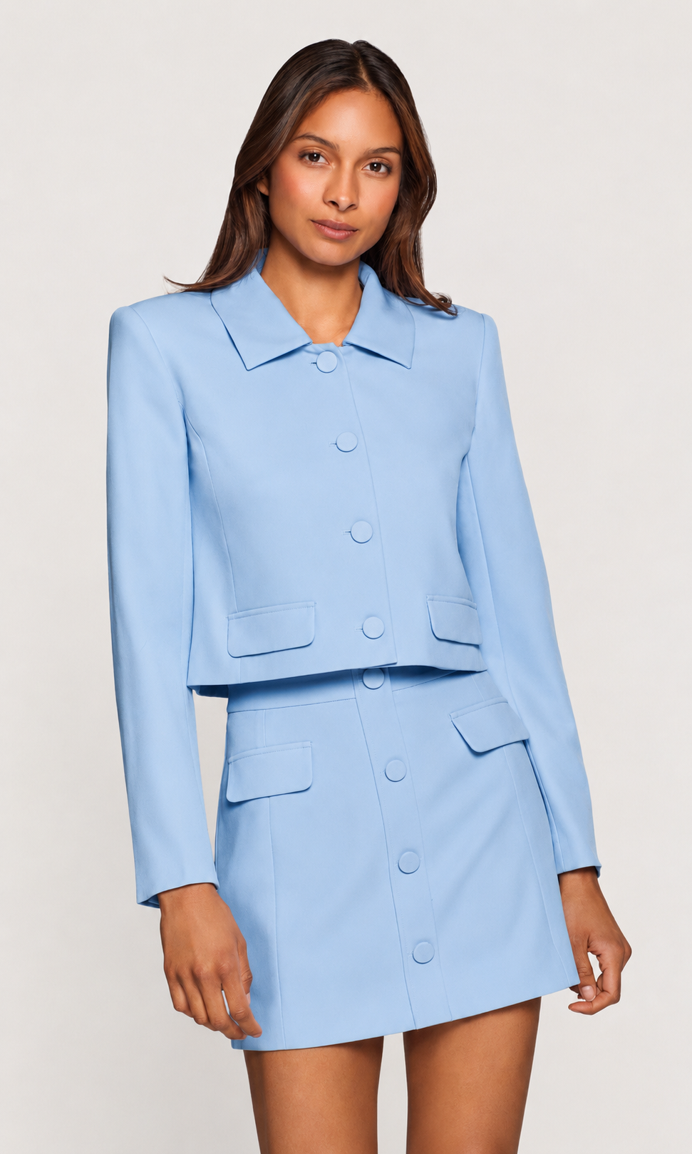 Woman wearing a light blue suit with a white background