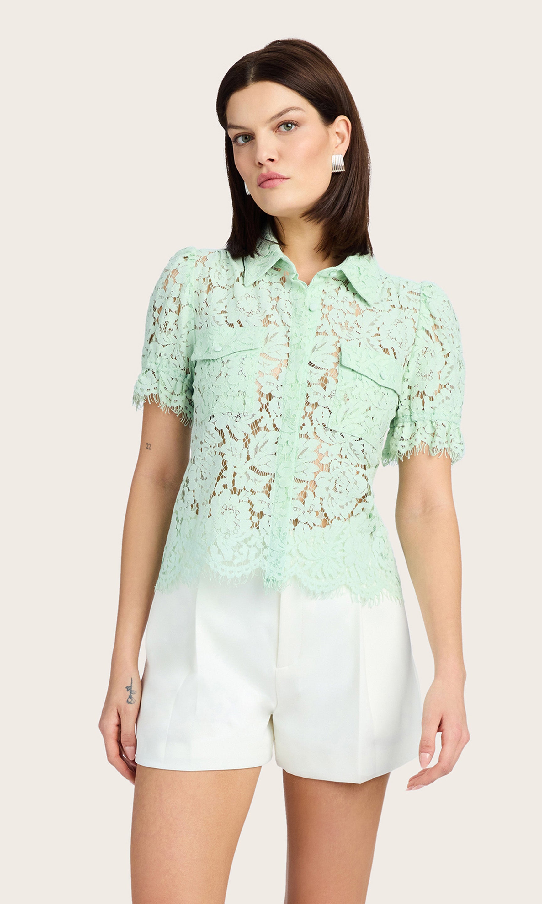 Front view showcasing the lace detailing and chest flap pockets of the mint green blouse