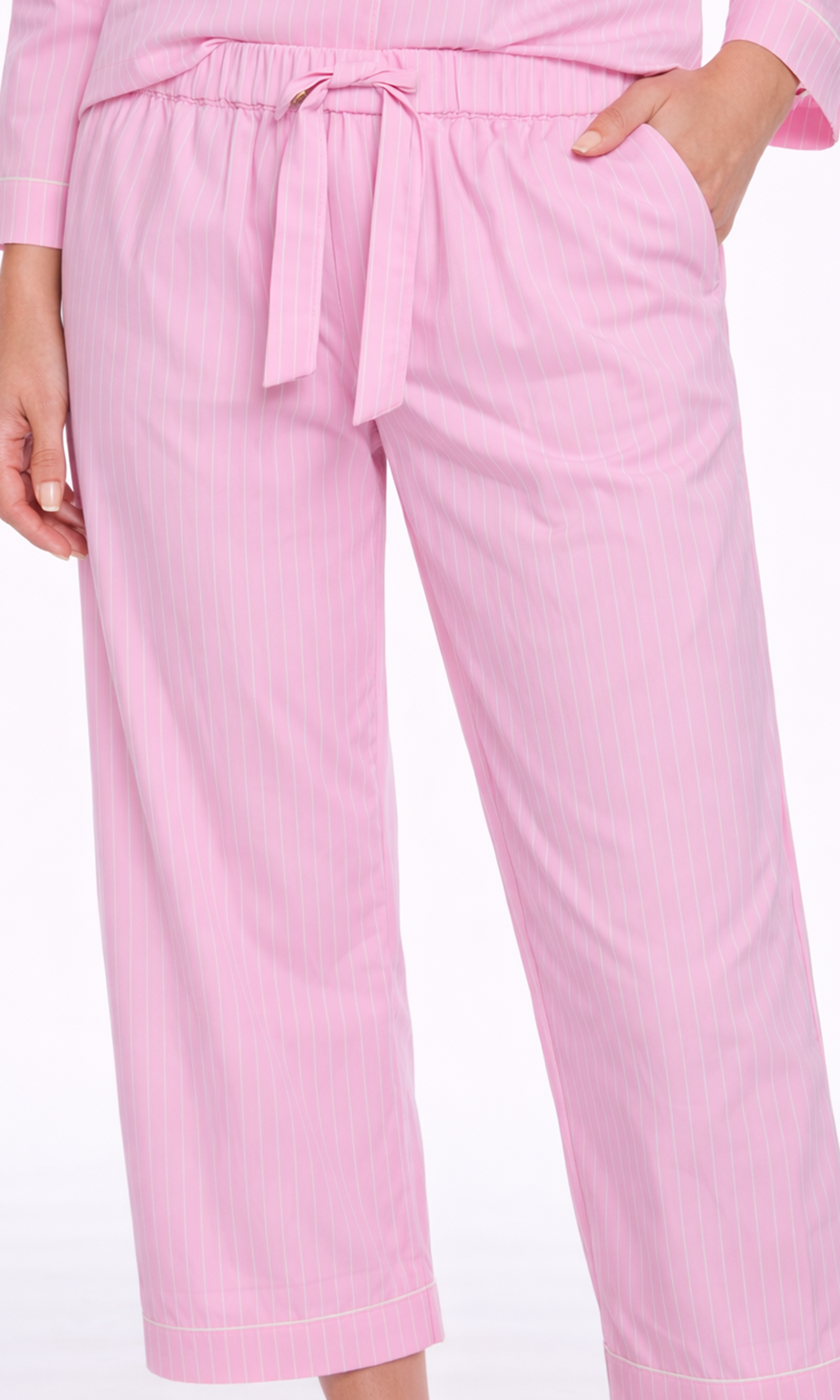 Close-up of pink pinstripe pajama pants with a drawstring waist on a white background