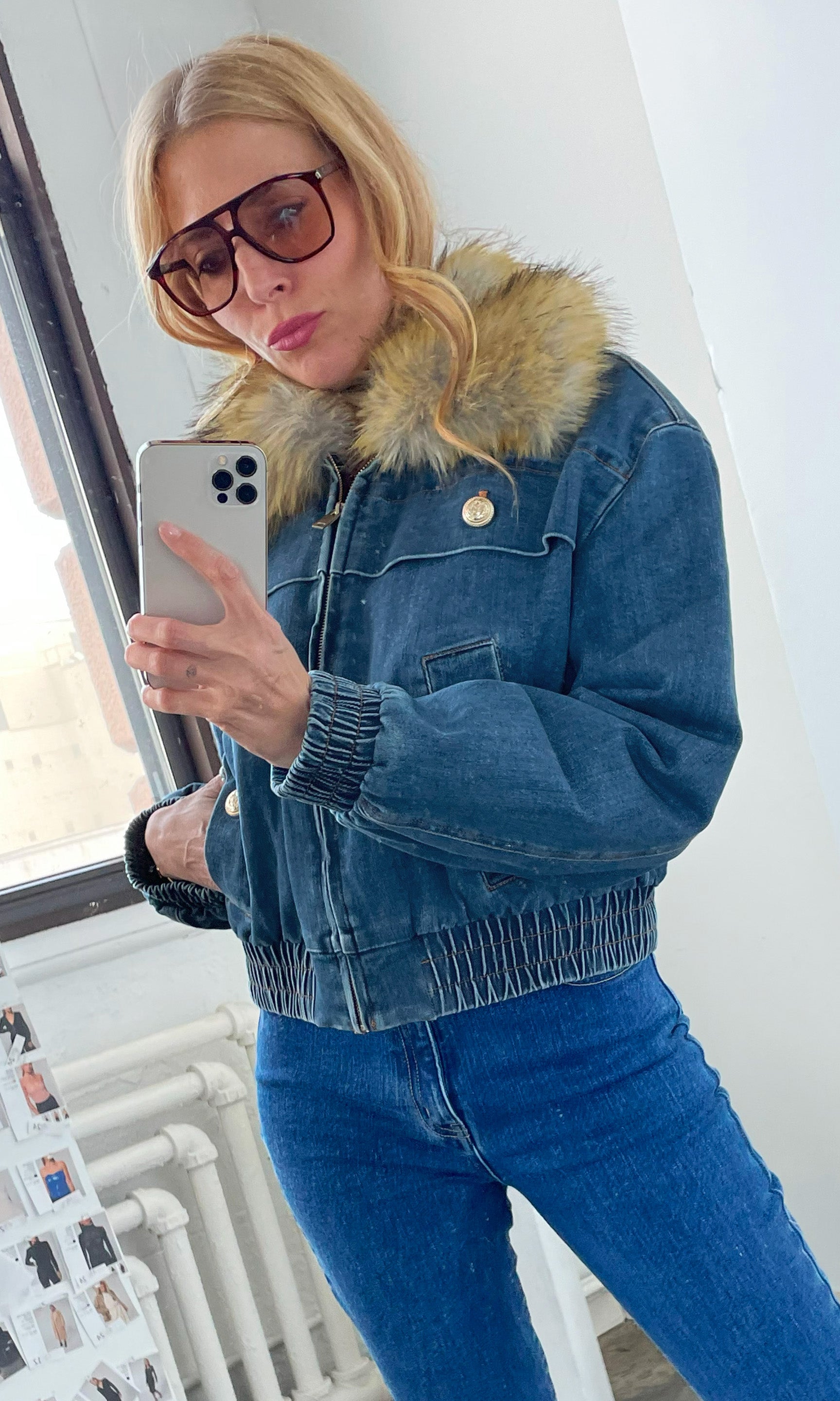 Image of our founder Roni wearing a blue denim jacket with fur collar, taking a selfie.