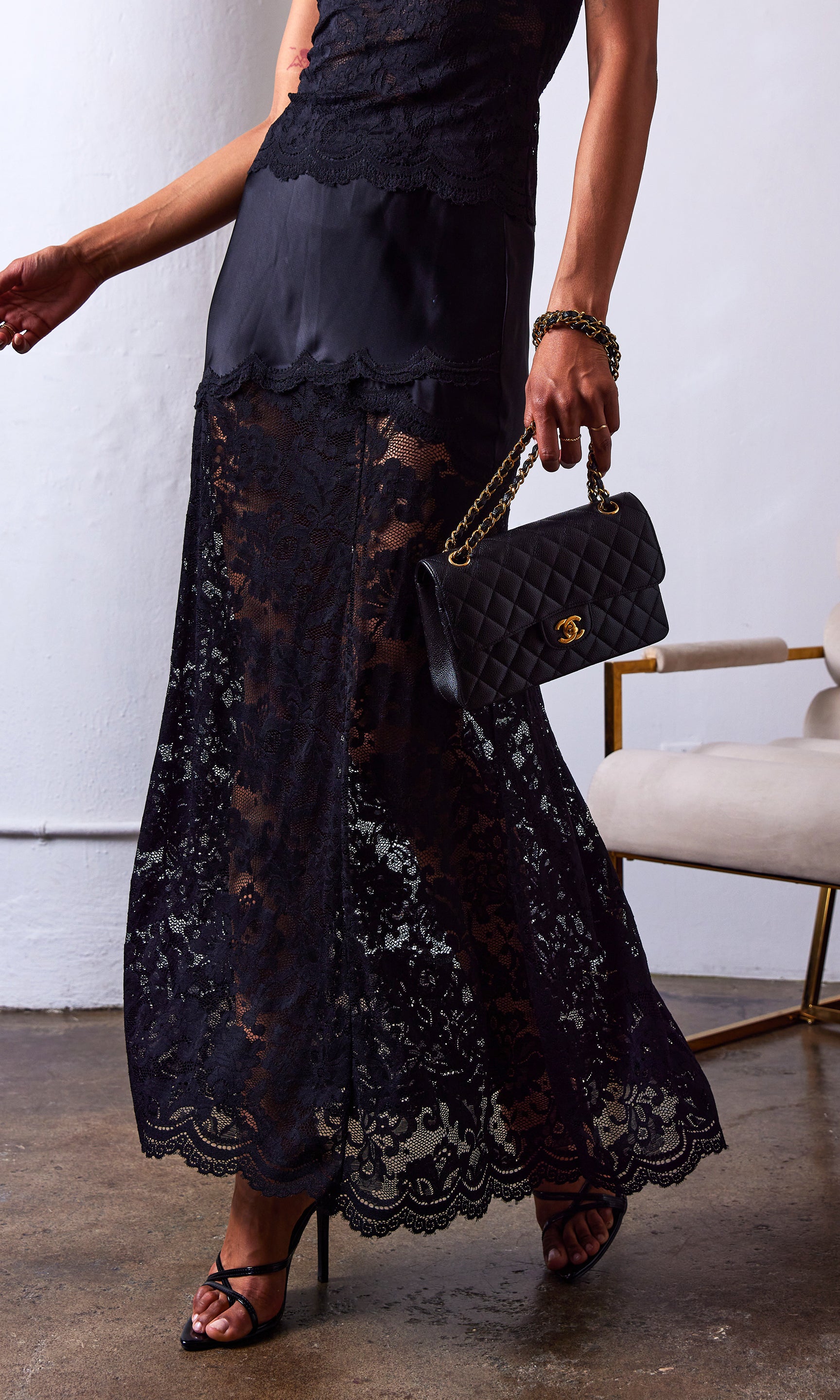 woman wearing a black lace skirt with a satin lining and paired with a black cami