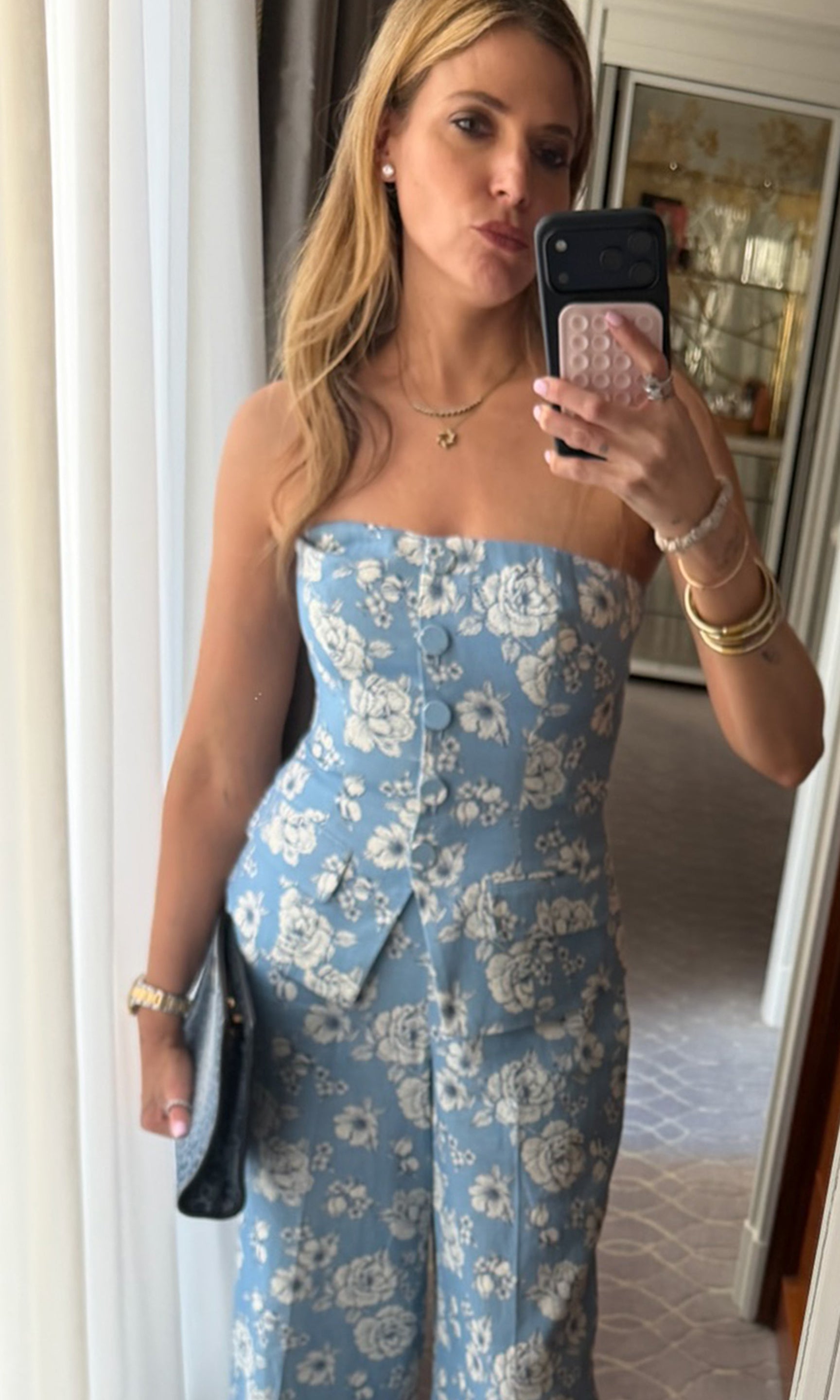 Our founder, Roni, taking a mirror selfie wearing a blue vestier and matching pant.
