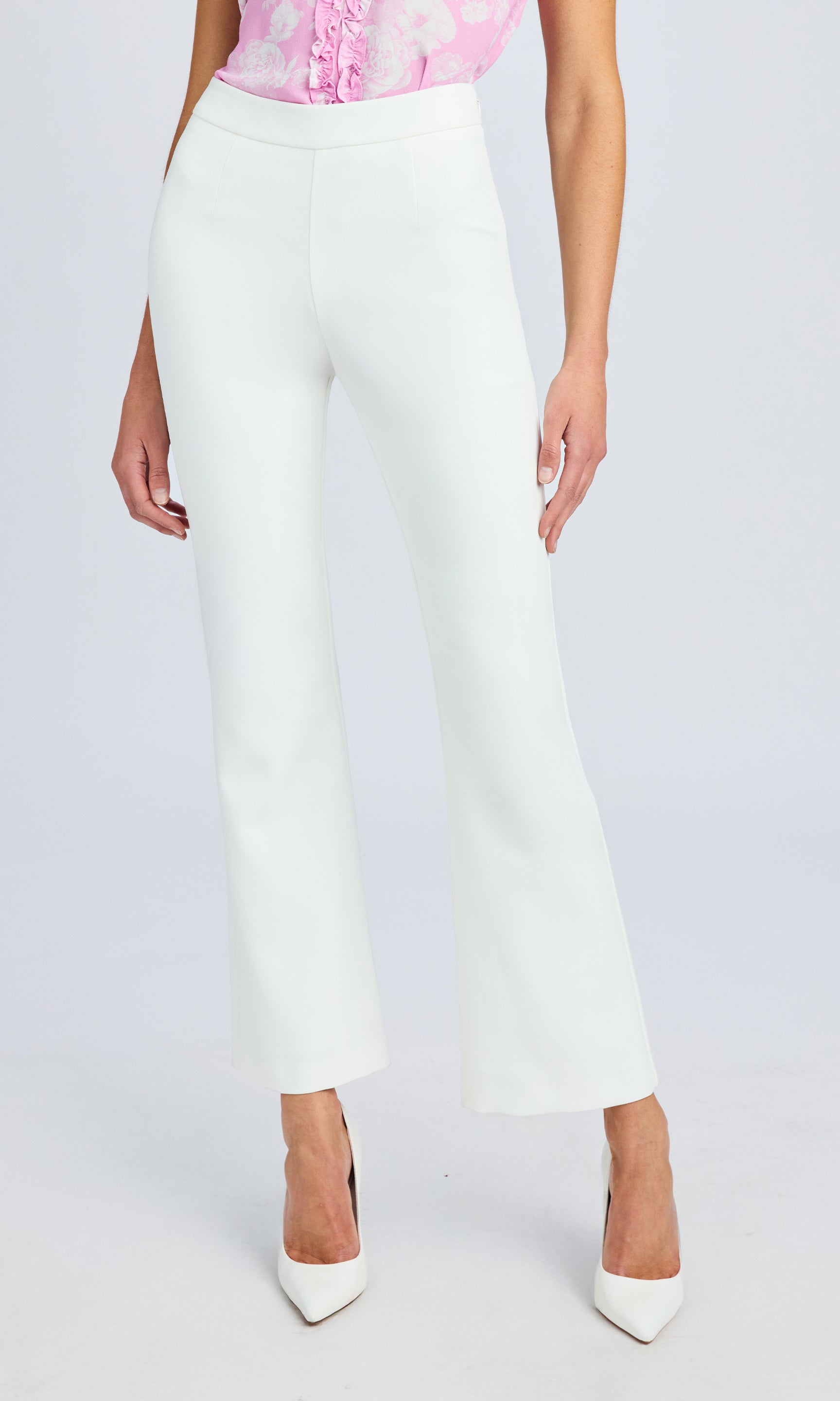 Front view of the white high-waisted pants, styled with a pink sleevless top.