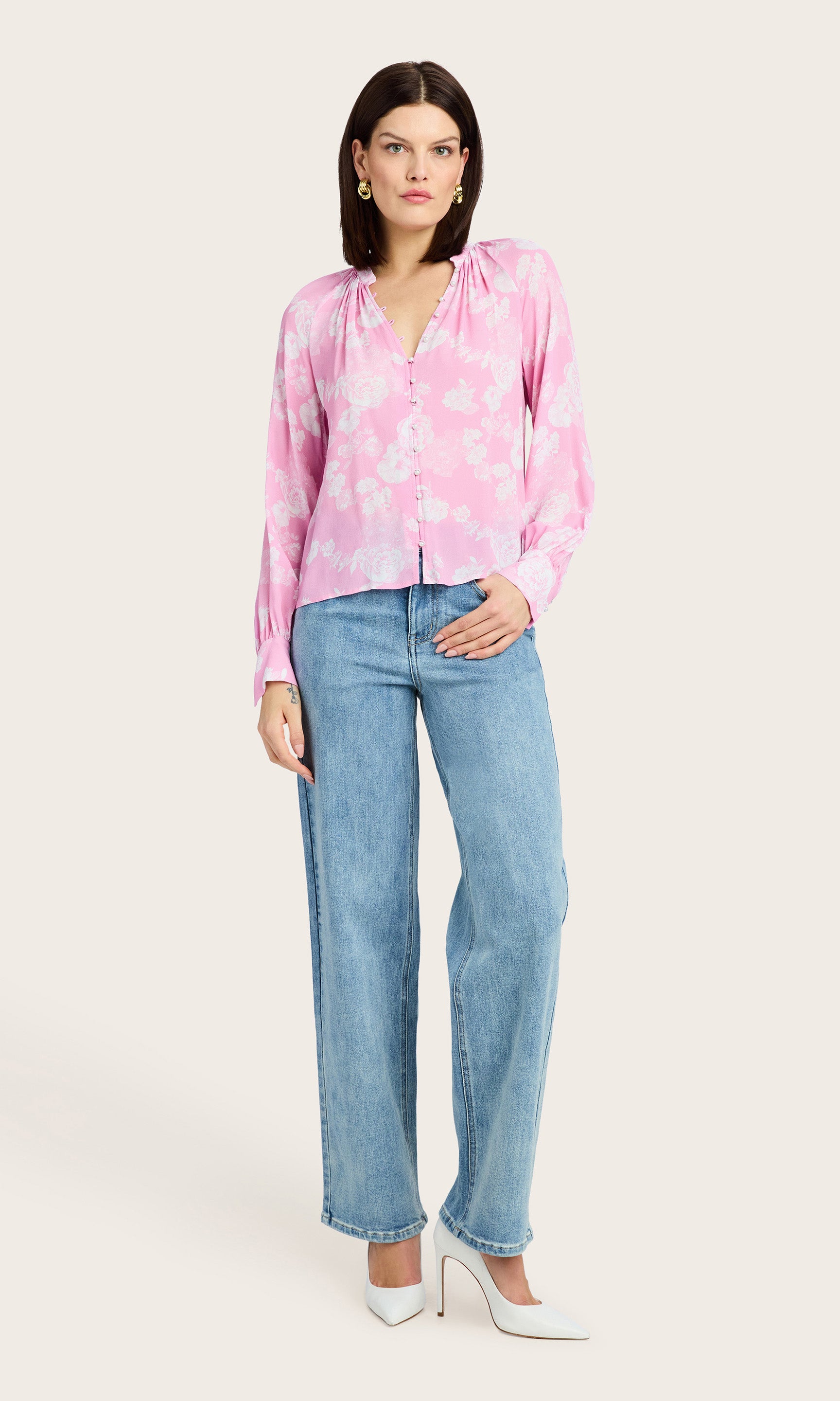 Full body front view of the model wearing the Sophia Floral Blouse paired with blue straight-leg jeans and white kitten heels.