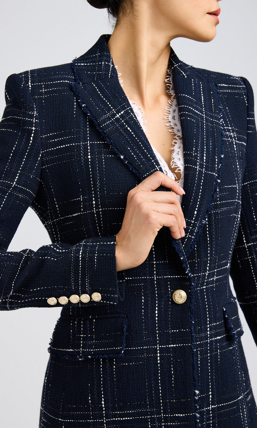 Close-up of woman wearing a navy/white tweed blazer with a single-button closure over a white shirt.