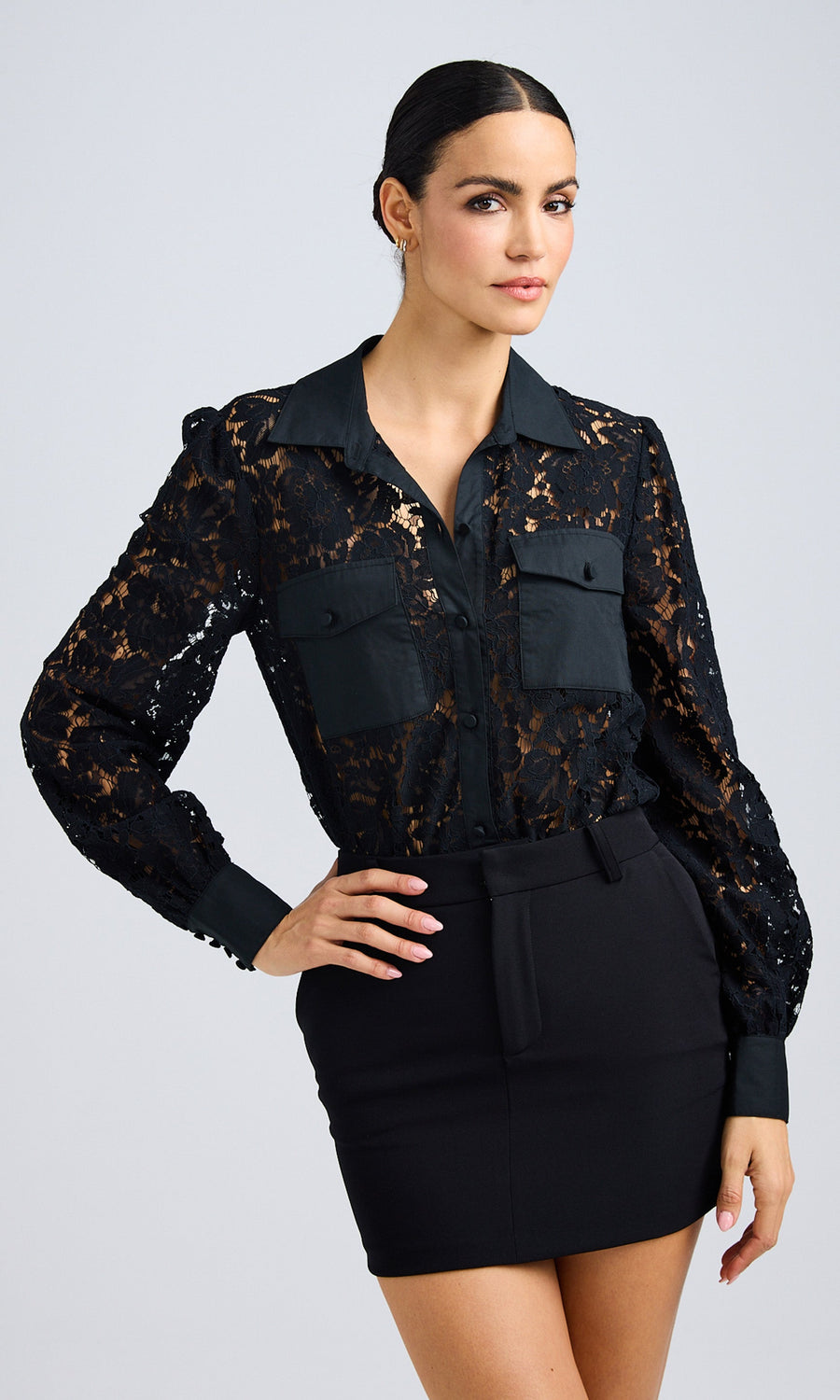 Front view of a model wearing a black lace poplin combo shirt styled with a sleek black mini skirt.