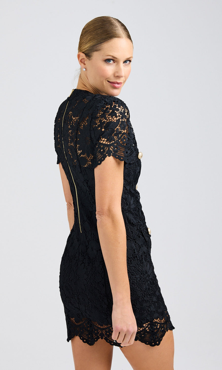 Rear view of the black lace dress, displaying the scalloped hemline and fitted design.