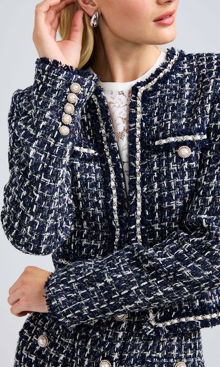 Close-up of the blazer highlighting the halo pearl buttons and intricate tweed texture.