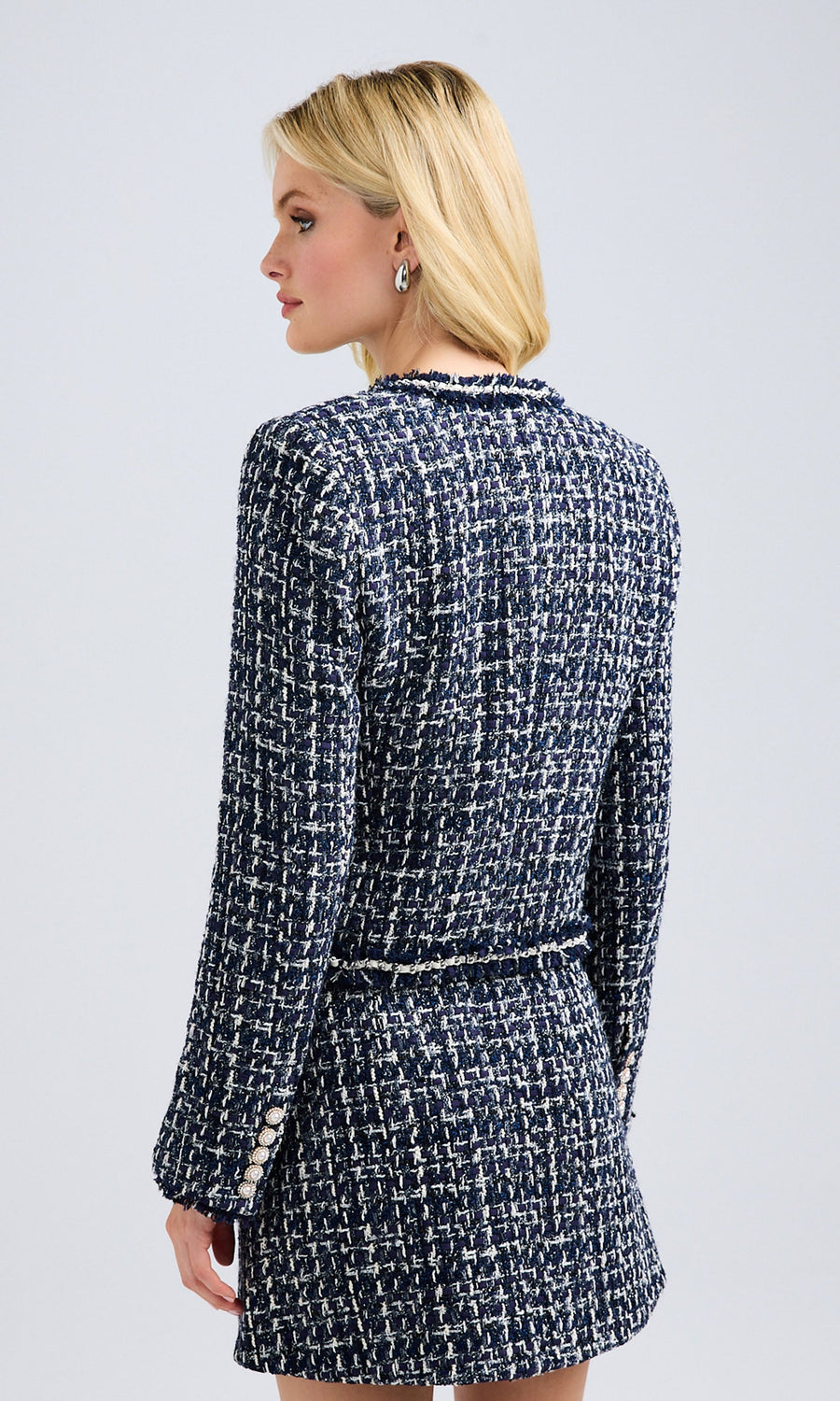 Side profile of the blazer, detailing its length and elegant silhouette.