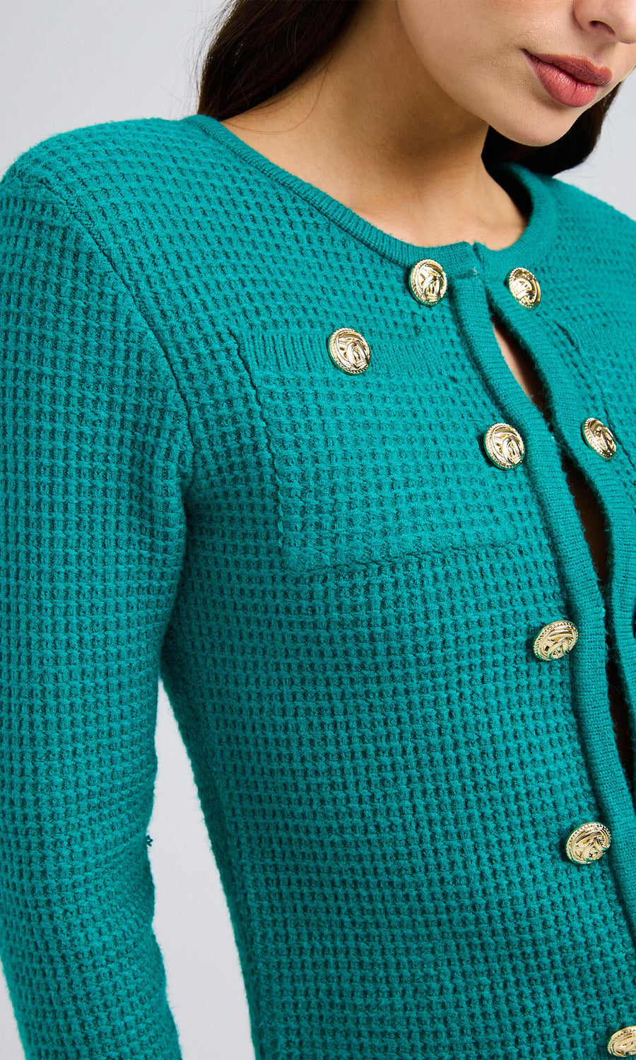 Close-up of a topaz waffle-knit sweater with gold front-closure buttons