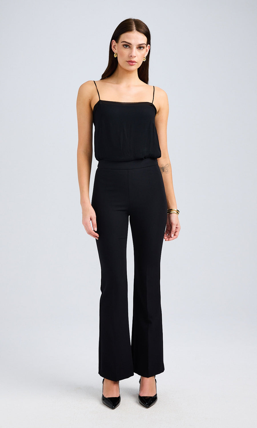 A stylish black crepe pants with fitted black top for a sleek look.