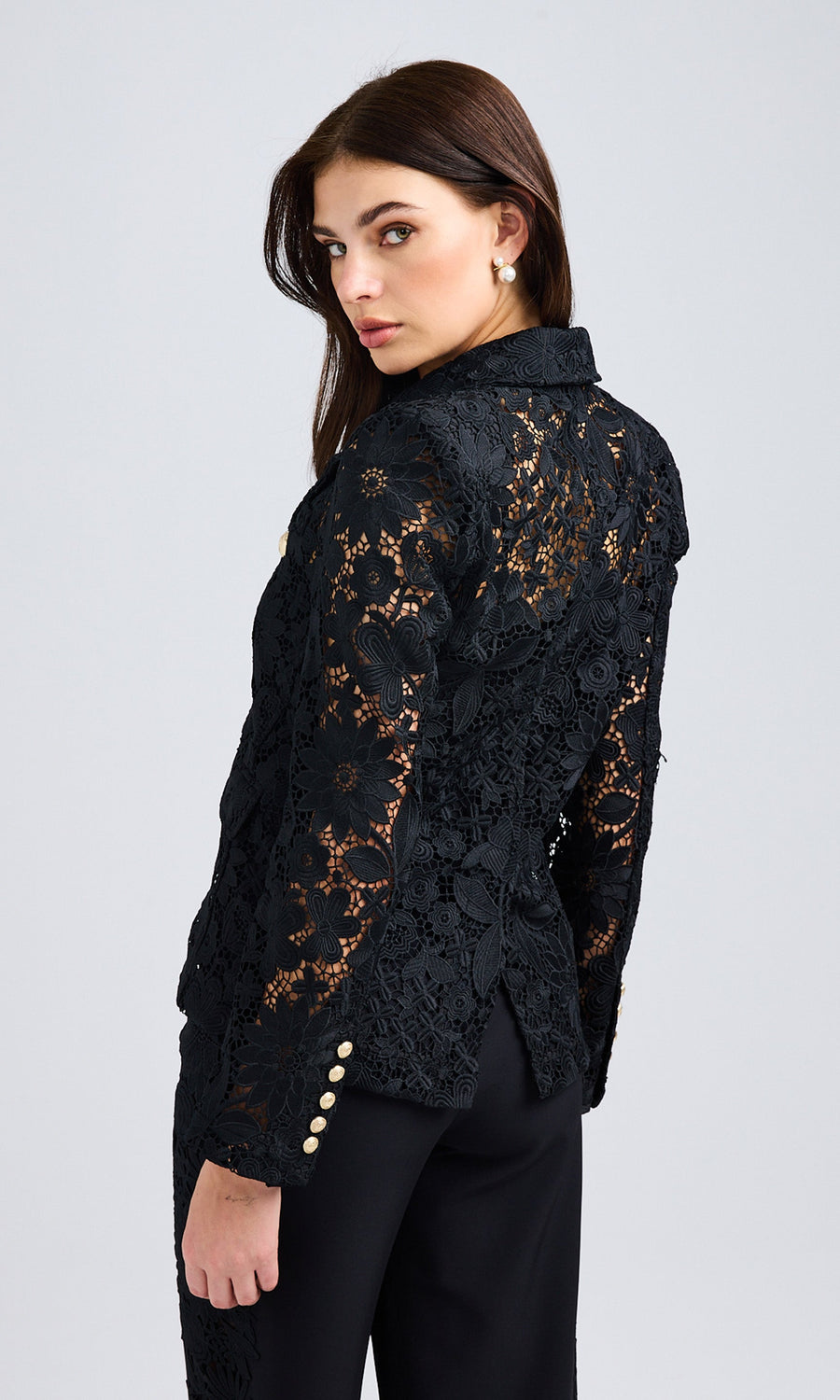 Side view of the black lace blazer, emphasizing its structured fit and scalloped hemline.