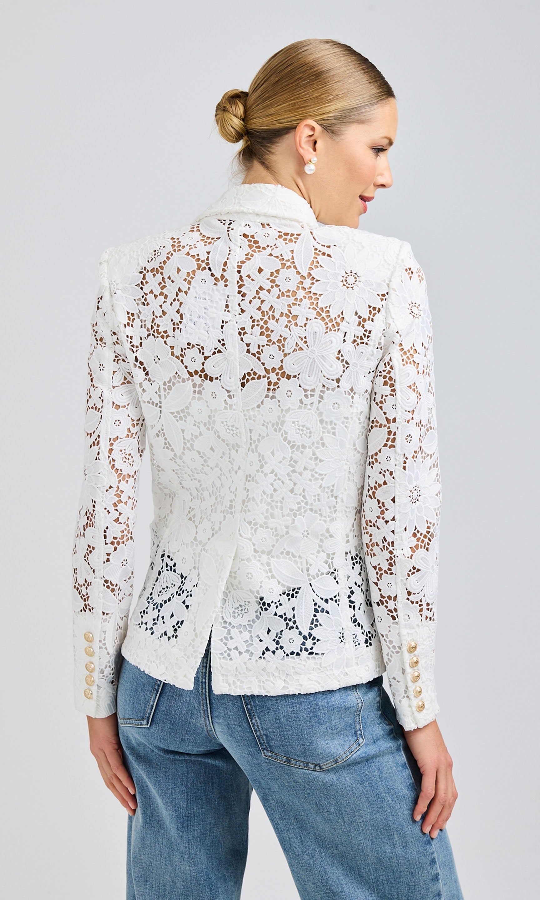 Rear view of the white lace blazer, emphasizing the intricate floral lace design and scalloped hem.