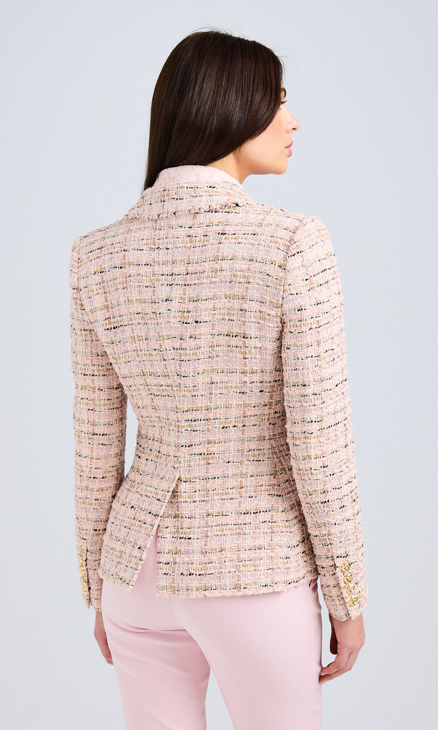 Back view emphasizing the contoured fit and structured tailoring of the tweed blazer