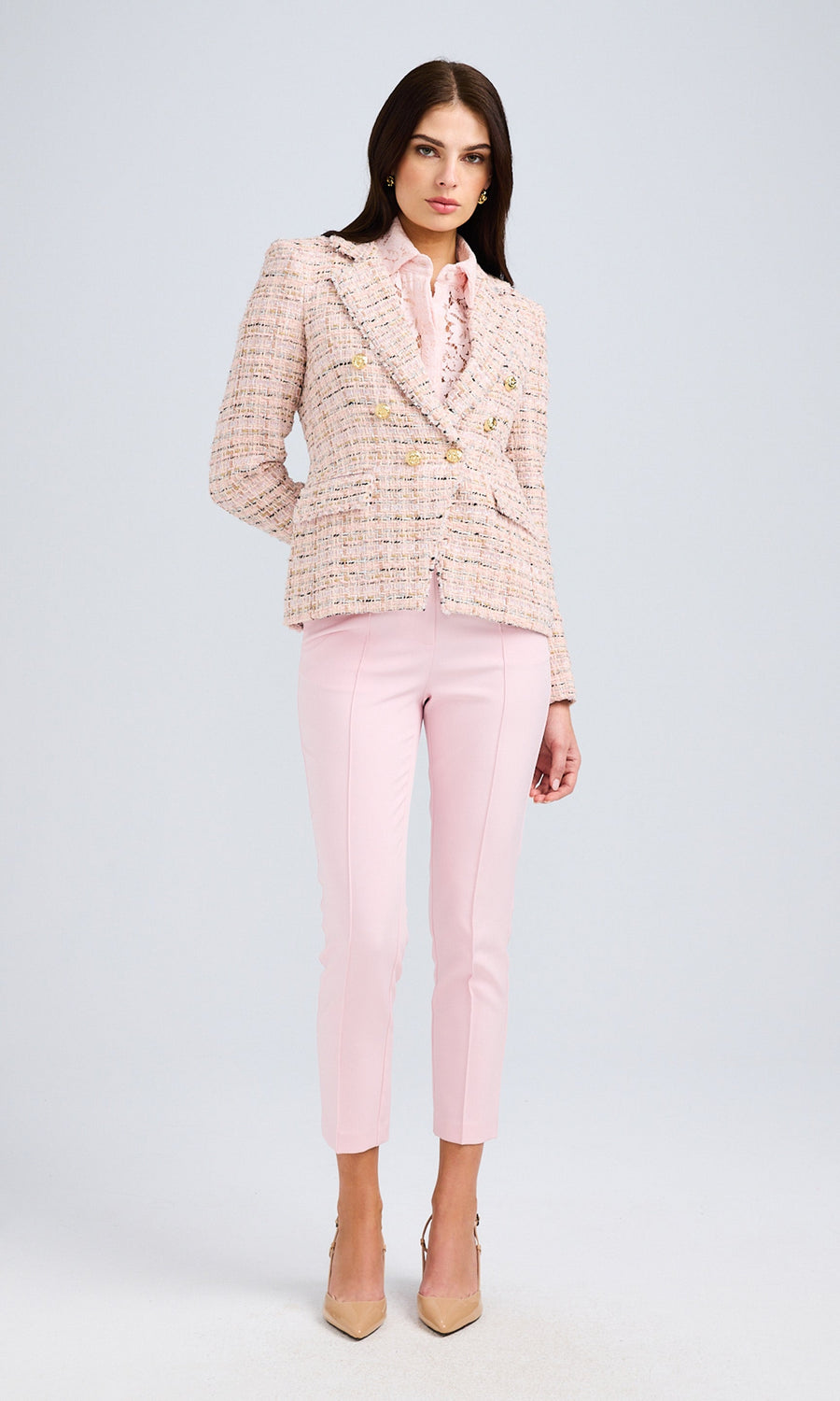 Full-body view showcasing the complete outfit with tailored trousers and neutral-toned heels