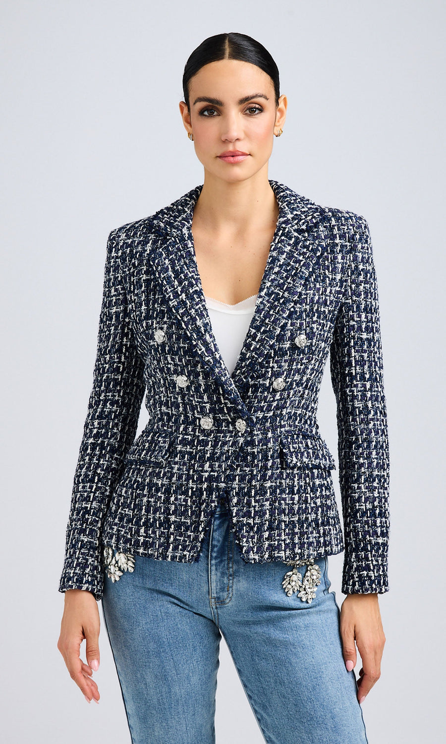 Front view of a navy and white tweed blazer styled with light blue denim jeans