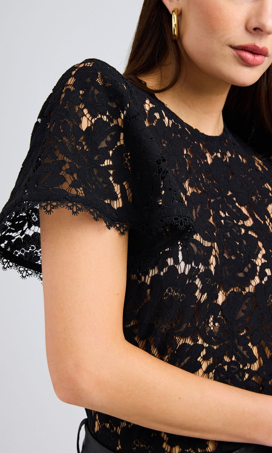 Close-up of the black lace vestier highlighting the crystal shank buttons and the intricate lace texture.