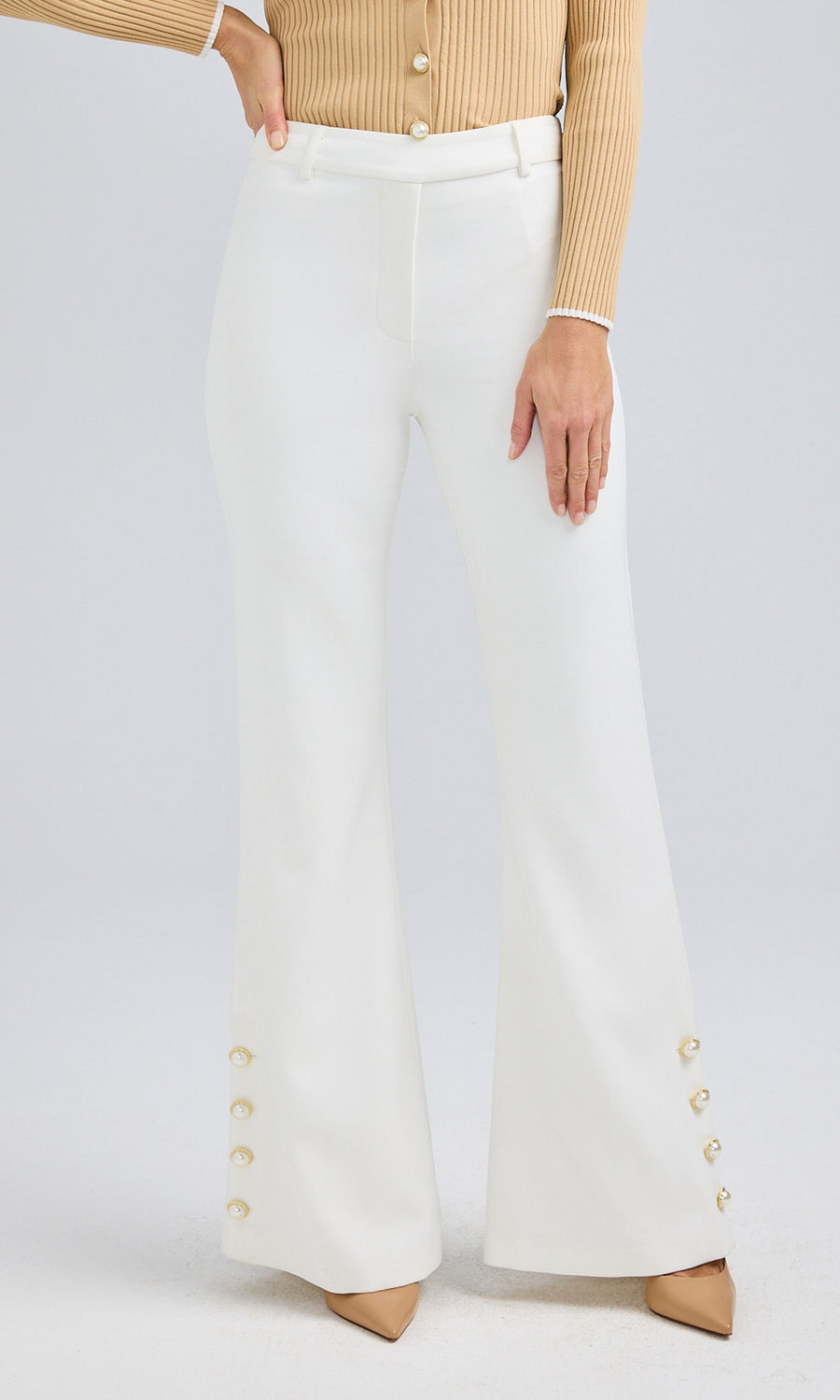 Front angle of white crepe pants and a beige cardigan, highlighting the tailored fit and hem details.