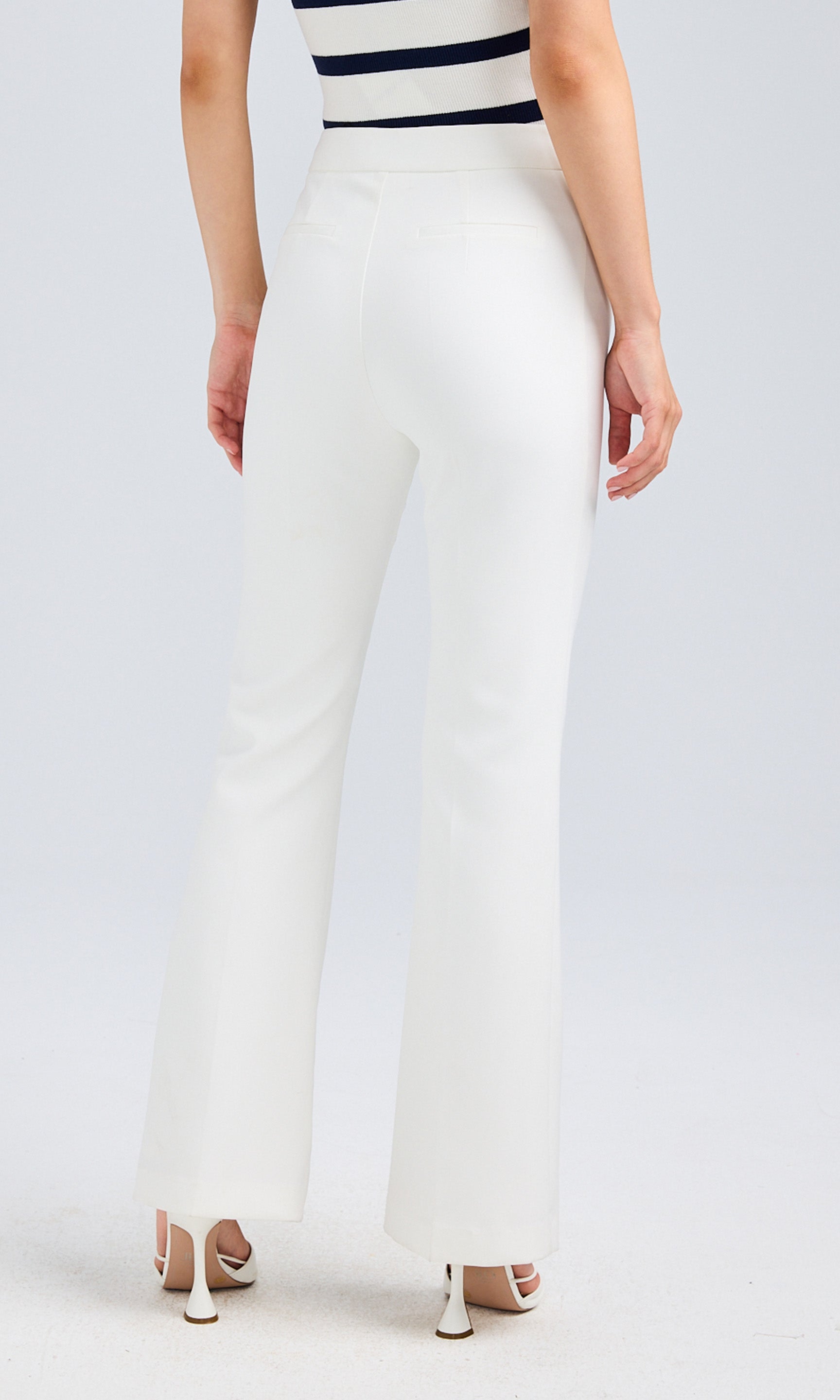 Back view of the white high-waisted pants, highlighting the fit and seam details.