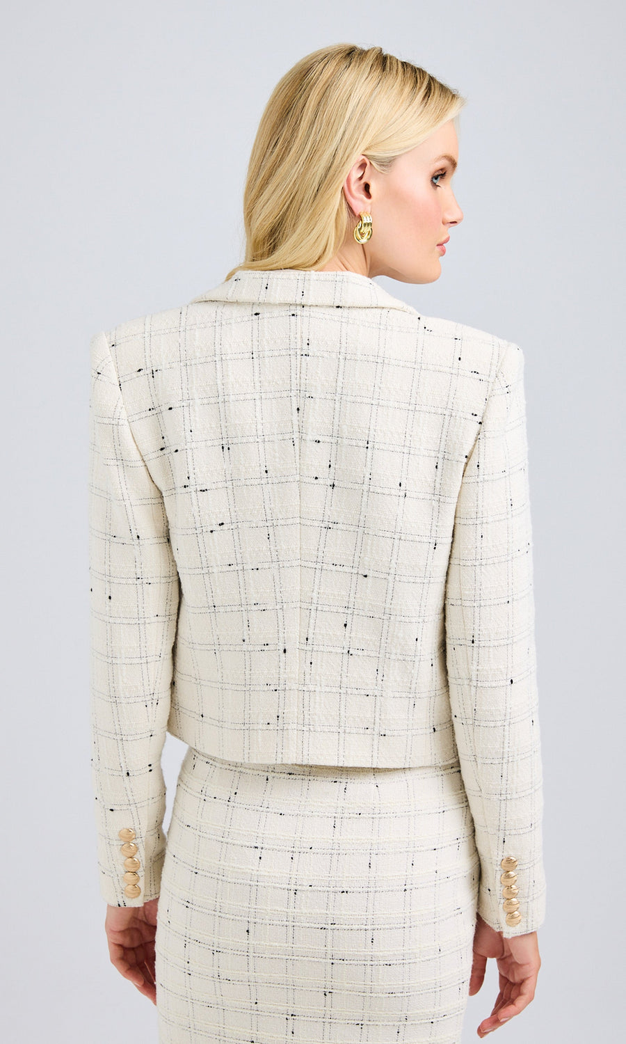 Back view of the white tweed cropped jacket, emphasizing the structured fit and clean silhouette.