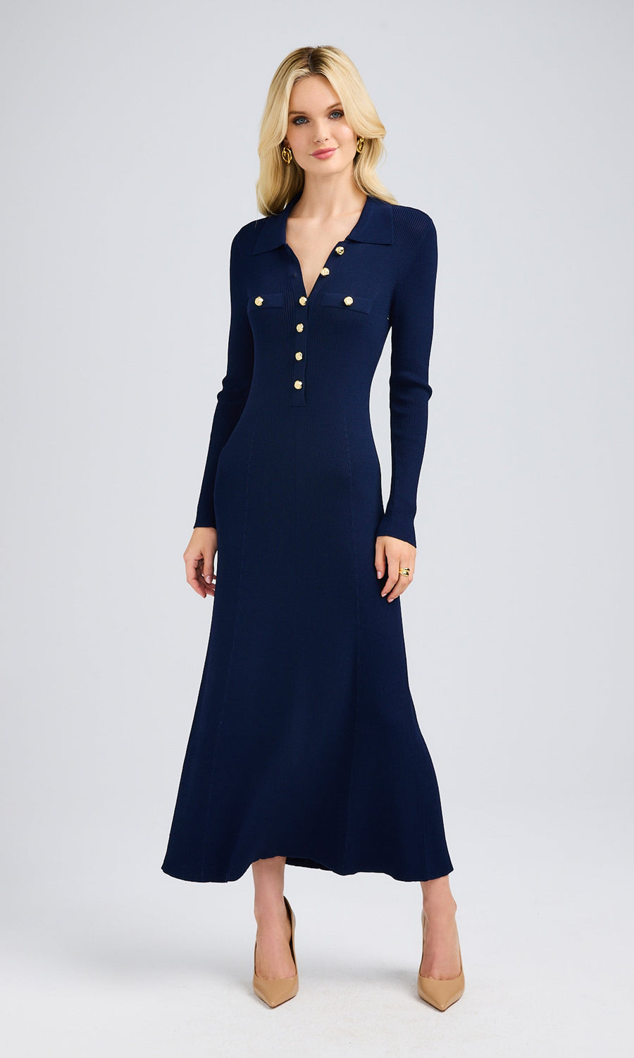 The model poses gracefully in a navy sweater dress, highlighting its soft knit fabric and flattering midi length