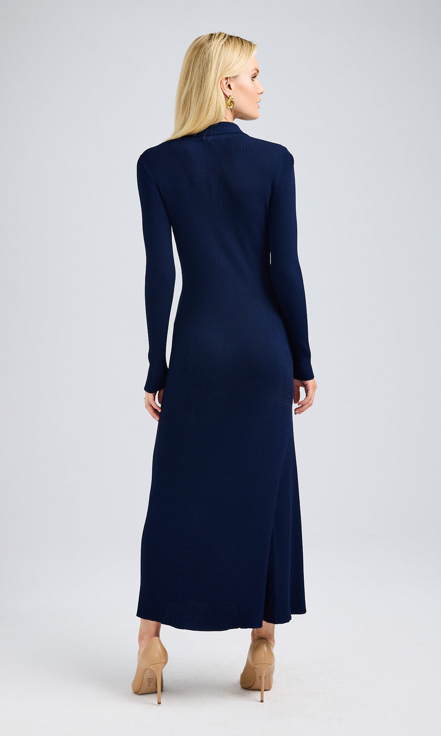 Rear view of a woman in a navy blue dress, showcasing her elegant posture and the dress's stylish design.