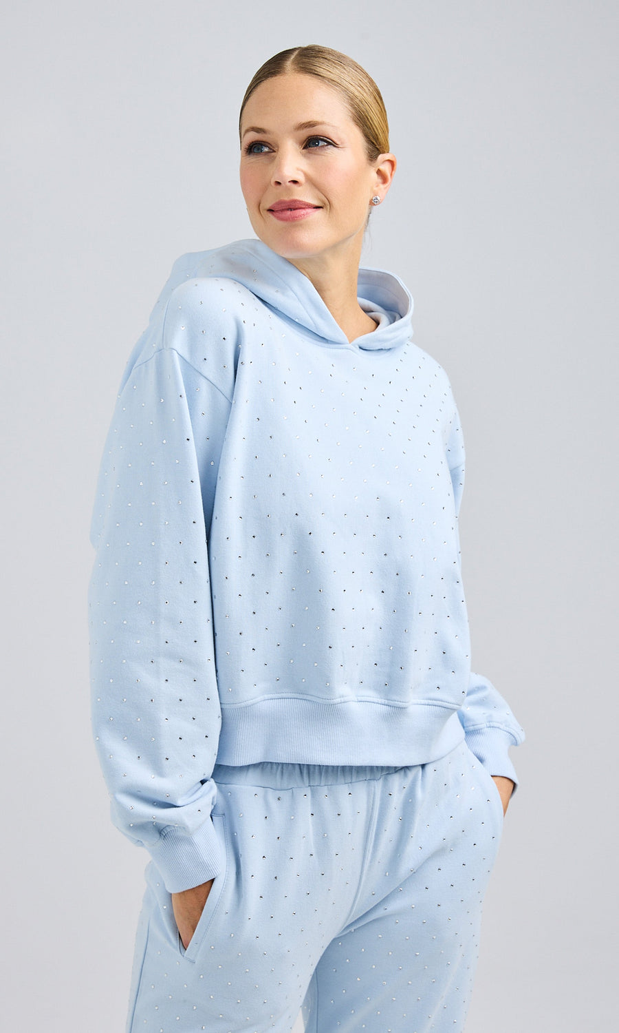 Model dressed in a light blue Renae Crystal hoodie and sweatpants, presenting a relaxed and trendy outfit.