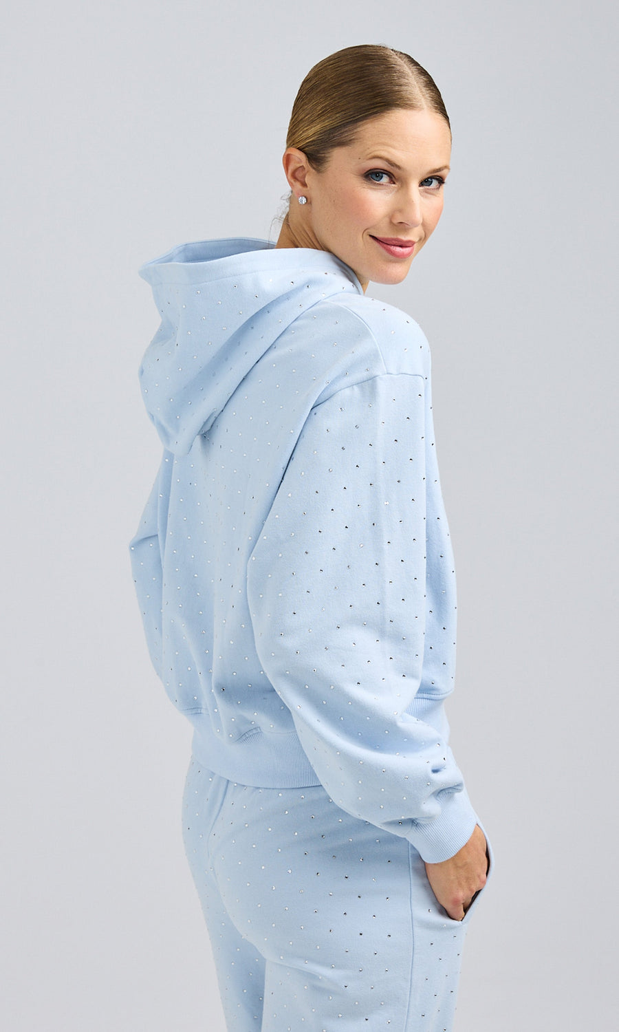 Side view of model wearing a blue sweatshirt and sweatpants, exuding a comfortable and laid-back style.