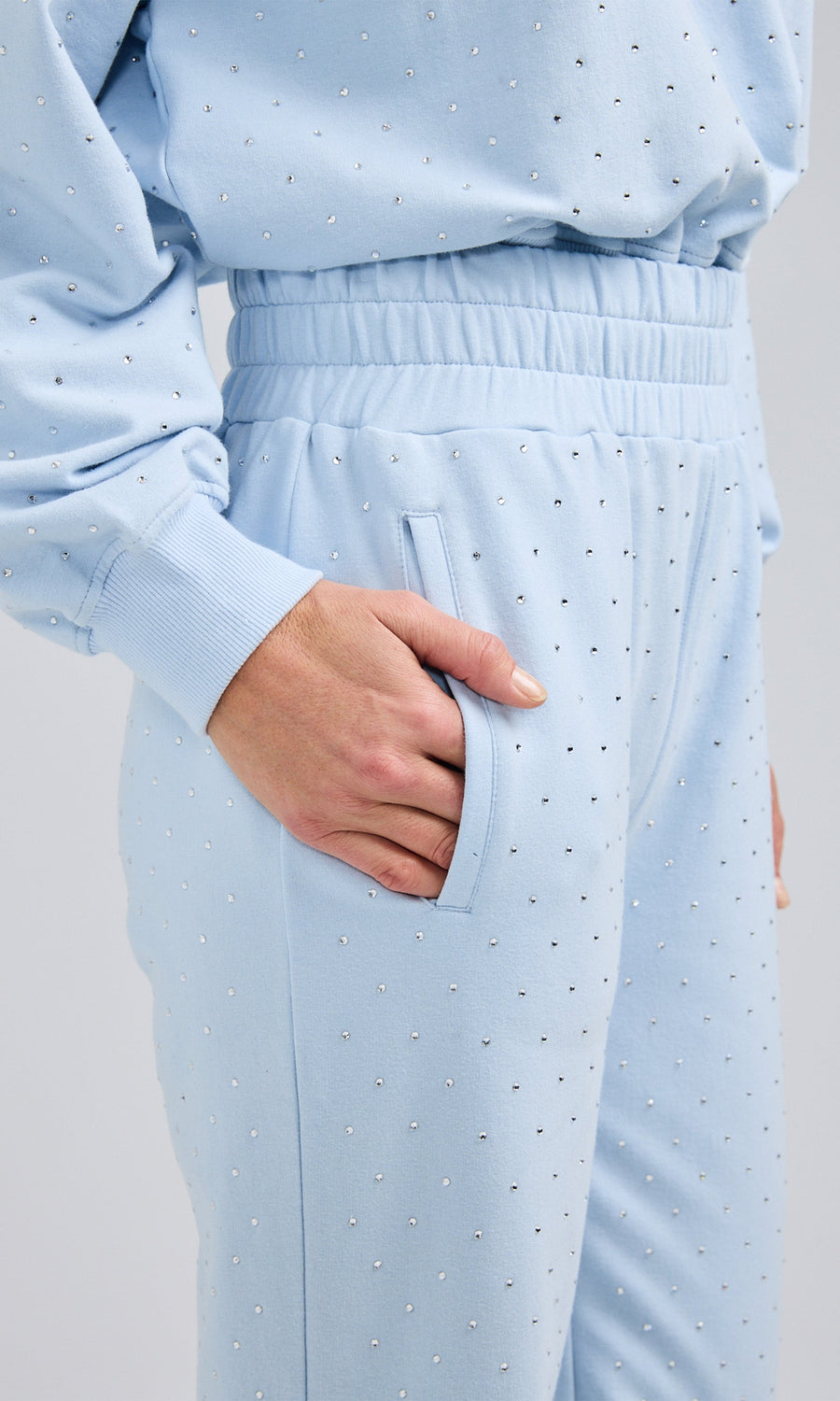 Close-up of blue sweatpants with crystals, showcasing the fabric texture and design details