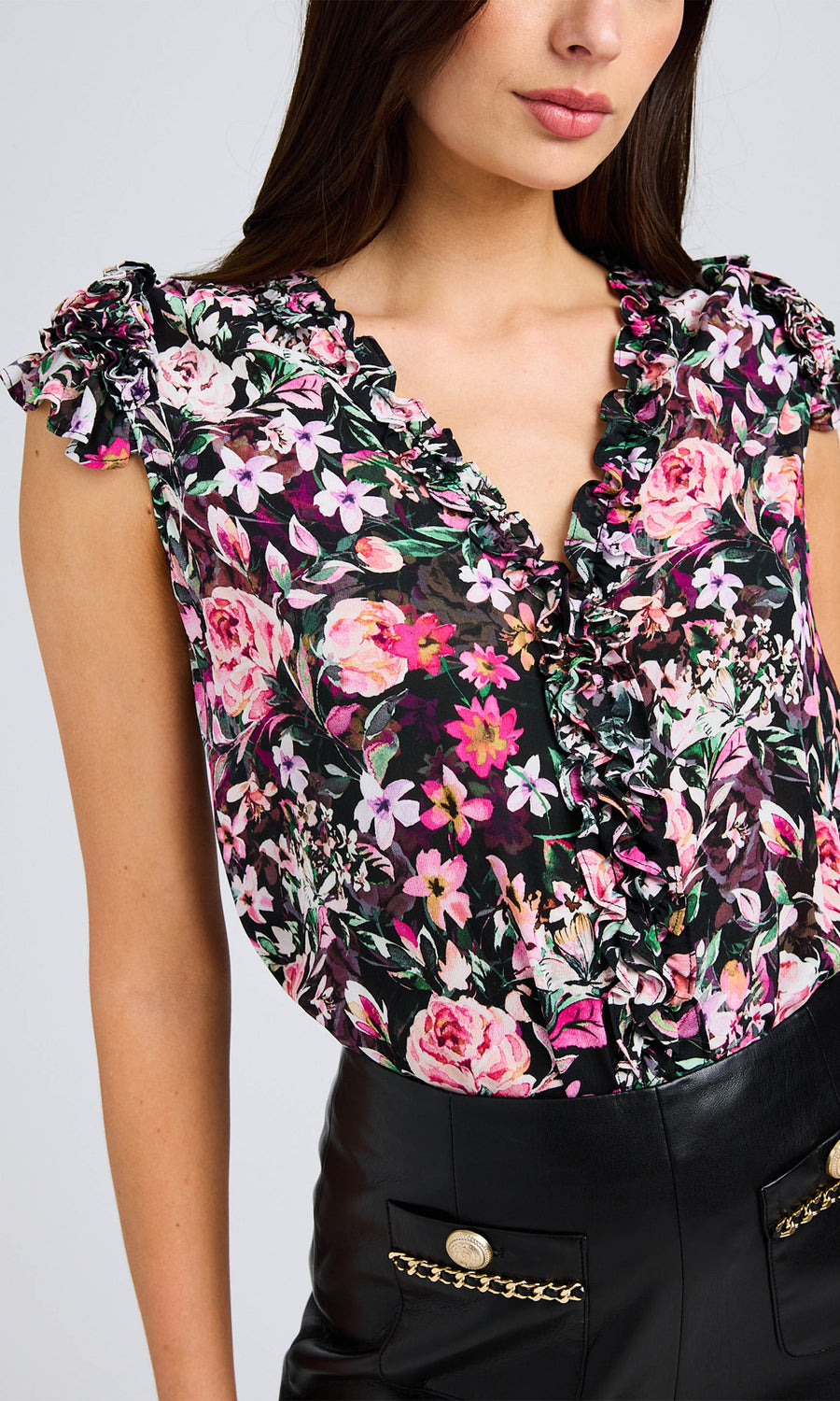 Close-up of the floral blouse highlighting the colorful print, ruffled neckline, and detailed fabric texture.