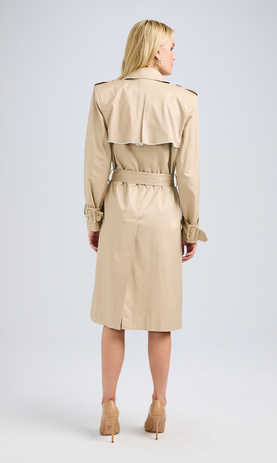 Full-body side view of the model showcasing the trench coat’s elegant cut and length.