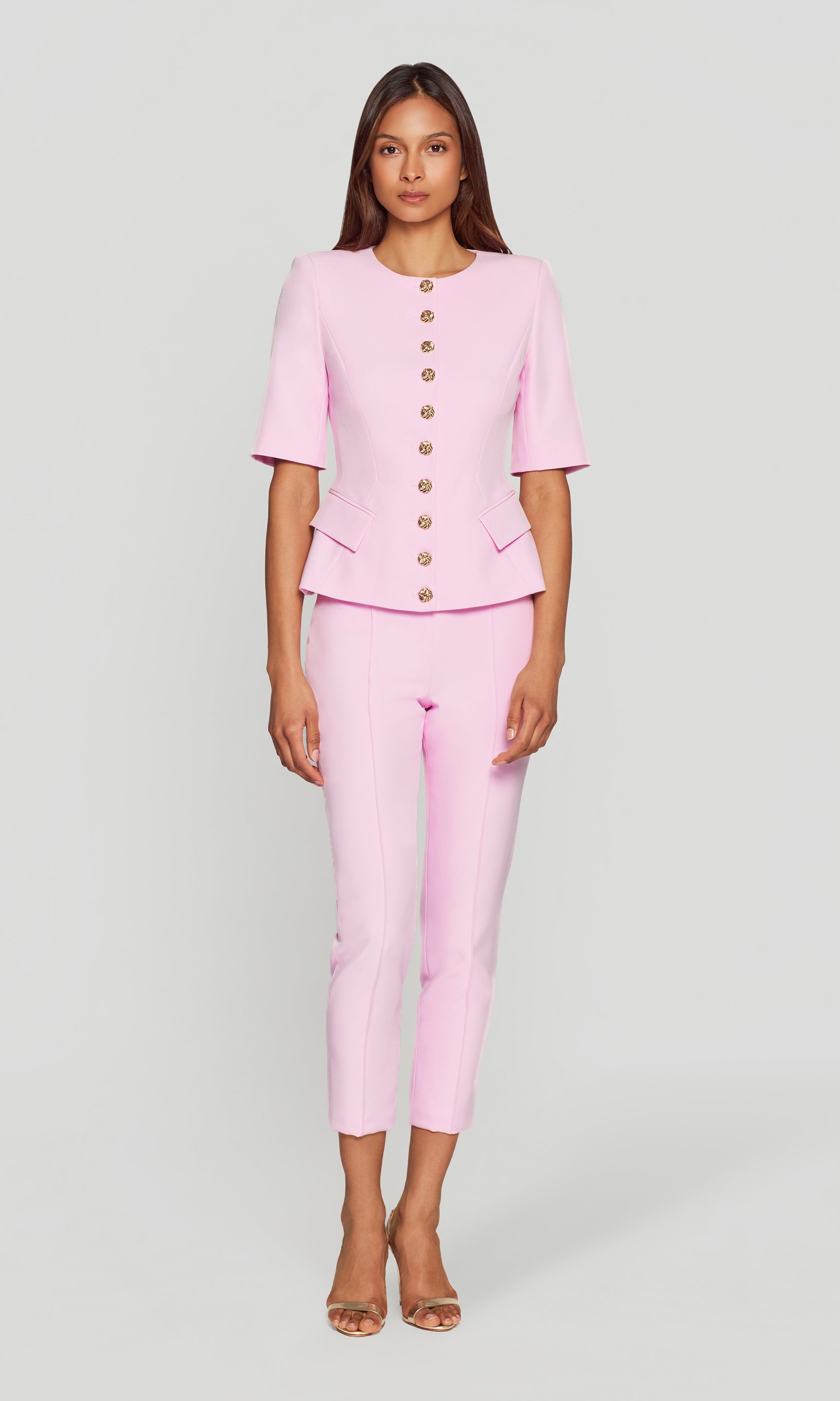 Woman wearing a pink suit with a white background